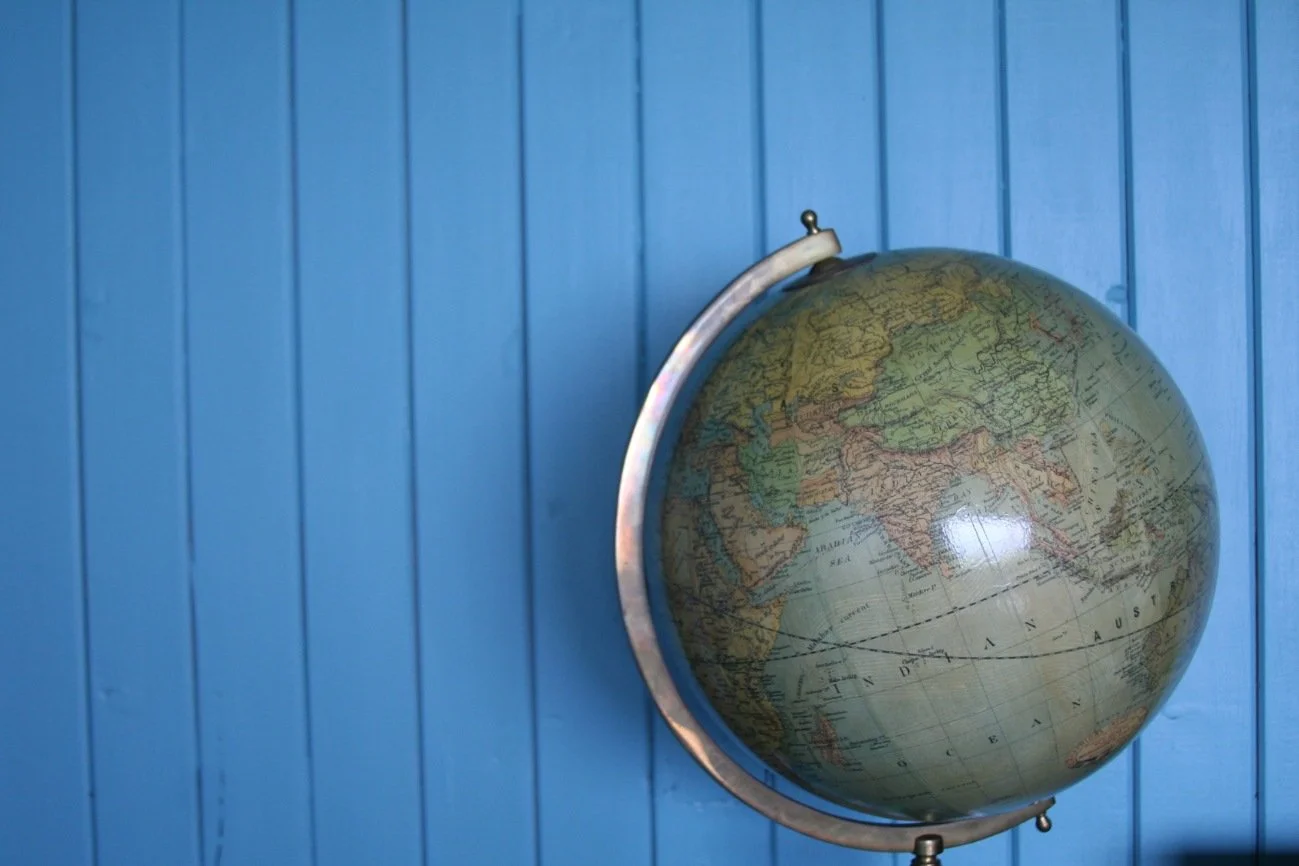 Globe with blue painted tongue and groove wall behind.