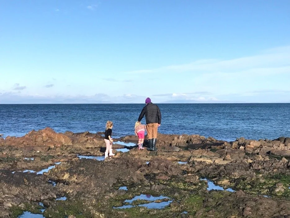 Man and children rock-pooling.