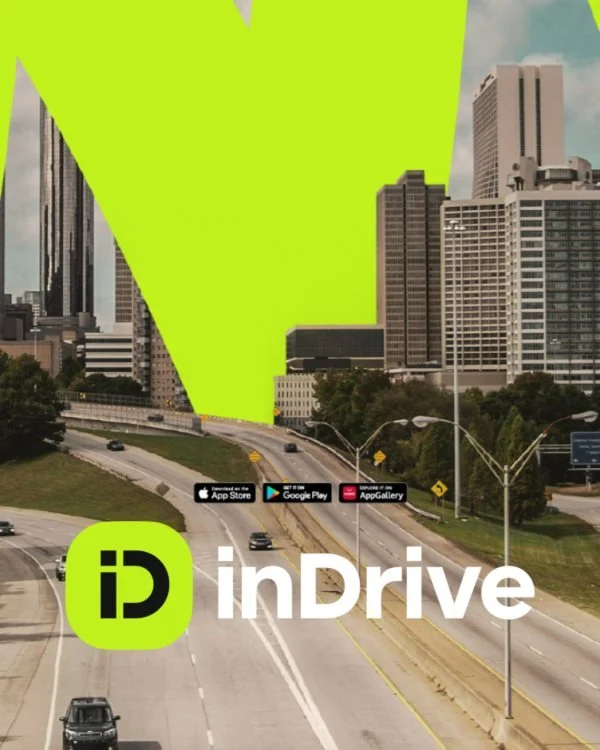 City skyline with tall buildings and a highway in the foreground, overlaid with the inDrive app logo and app store download badges.