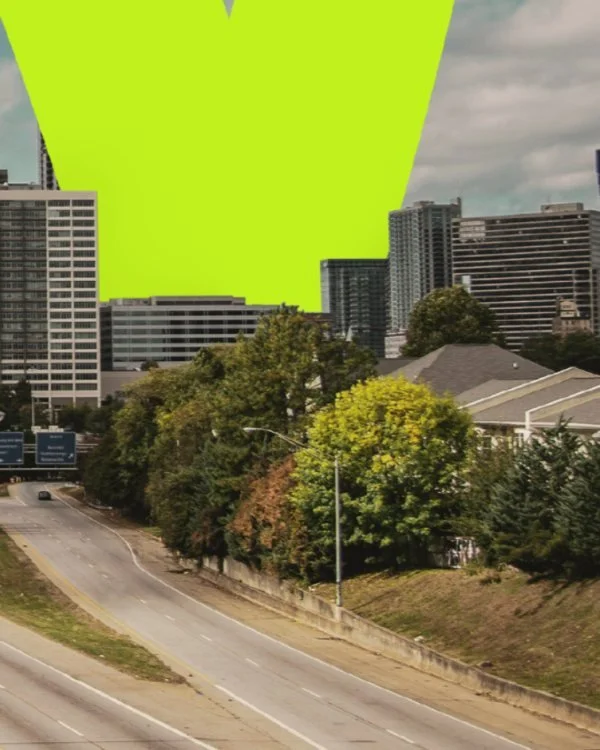 Cityscape with tall buildings, trees, and a highway, with a bright green overlay partially covering the sky.