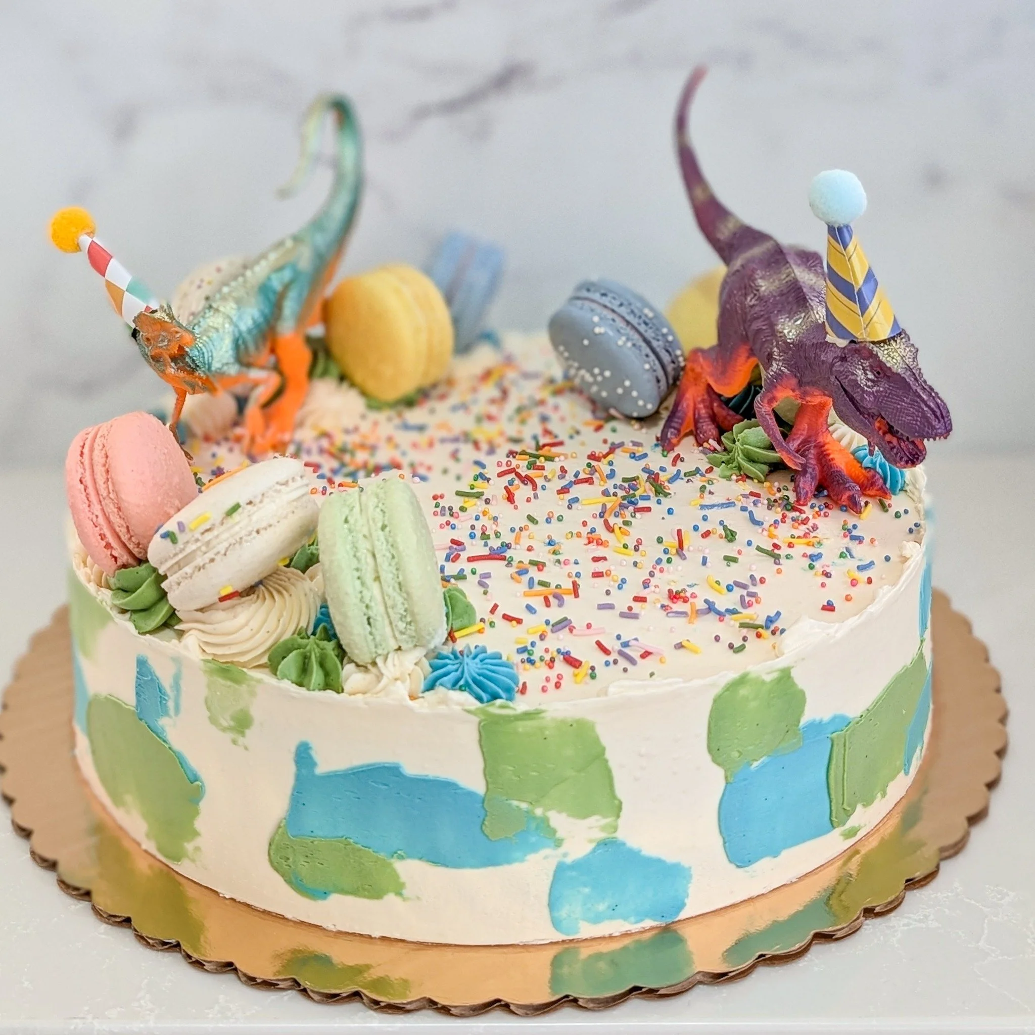 Have you ever seen dinosaurs in party hats? It's pretty awesome. 
.
To order your own custom cake:
Email us here: info@whiskandarrow.com
or call us: 920-815-3645
.
-Cake details-
Size: 10-inch shorty
Add-ons: green and blue smudges + sprinkles + dino