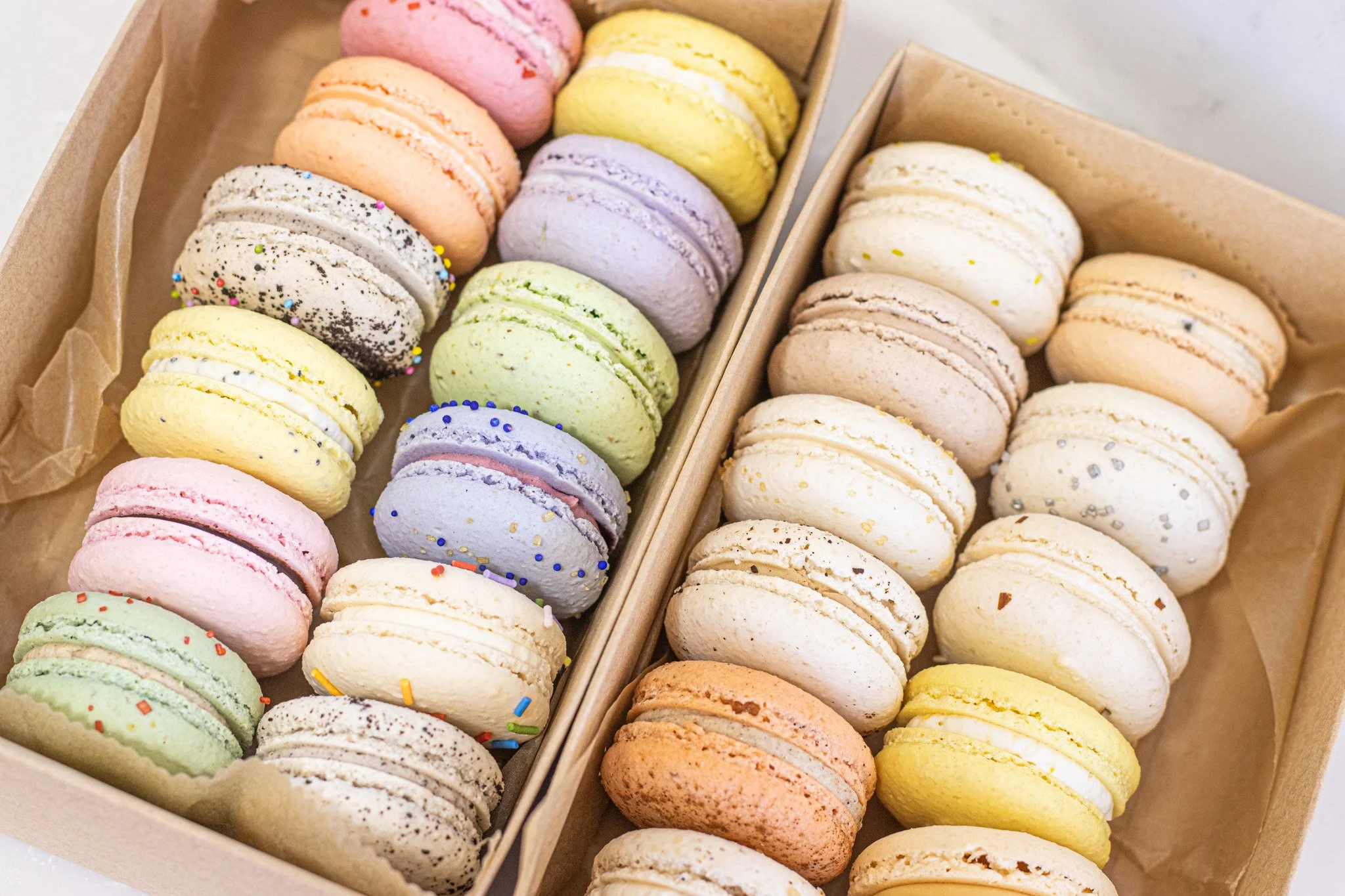 Our Macarons are the best, trust me. We have over 20 unique and classic flavors to choose from. We make them entirely from scratch, which means we also sell bags of broken macaron shells, which are delicious even on their own. We fill our macarons wi