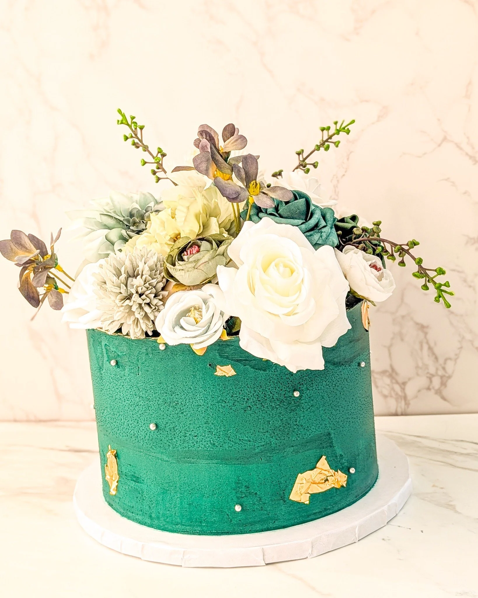 This deep green color is so pretty, and goes so well with the gold. The flowers absolutely give this cake life. 
.
We can make any of our cakes to look like this. There is at least a $40 upcharge for this design, depending on if you source the flower
