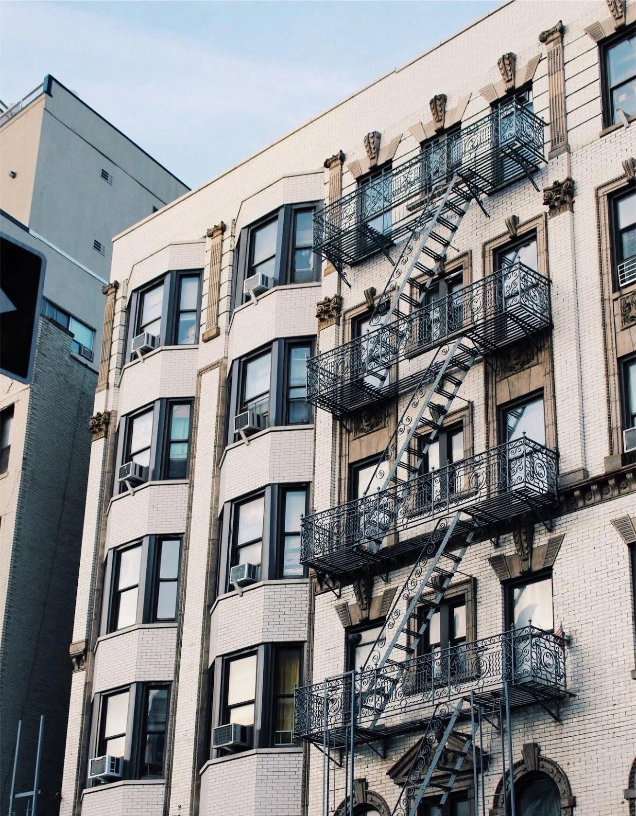 Multi-story brick building with fire escapes attached to its facade