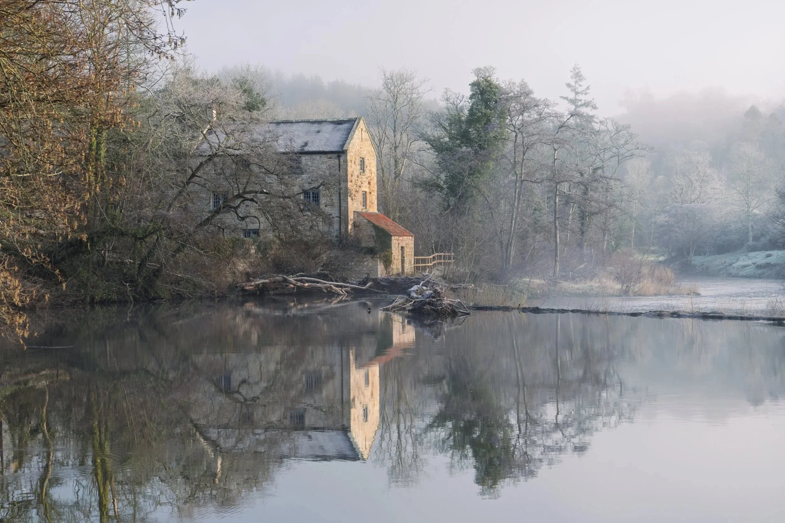 An early winter morning over the river coquet with old mill and mist covered river and trees by Jim Scott Photography
