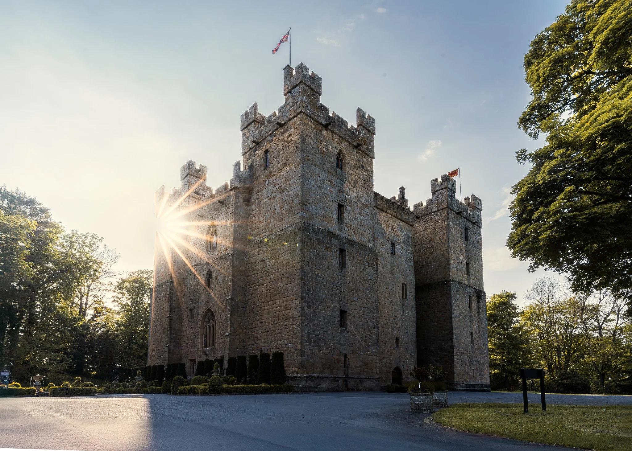 Langley castle with sunstar, by Jim Scott Photography