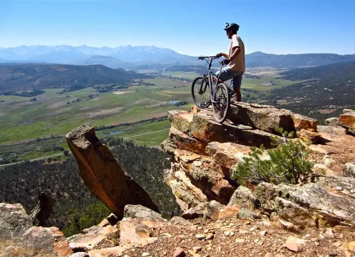 Cyclist overlooking valley: Cyclist overlooking the valley and mountains near Ridgway, Colorado.