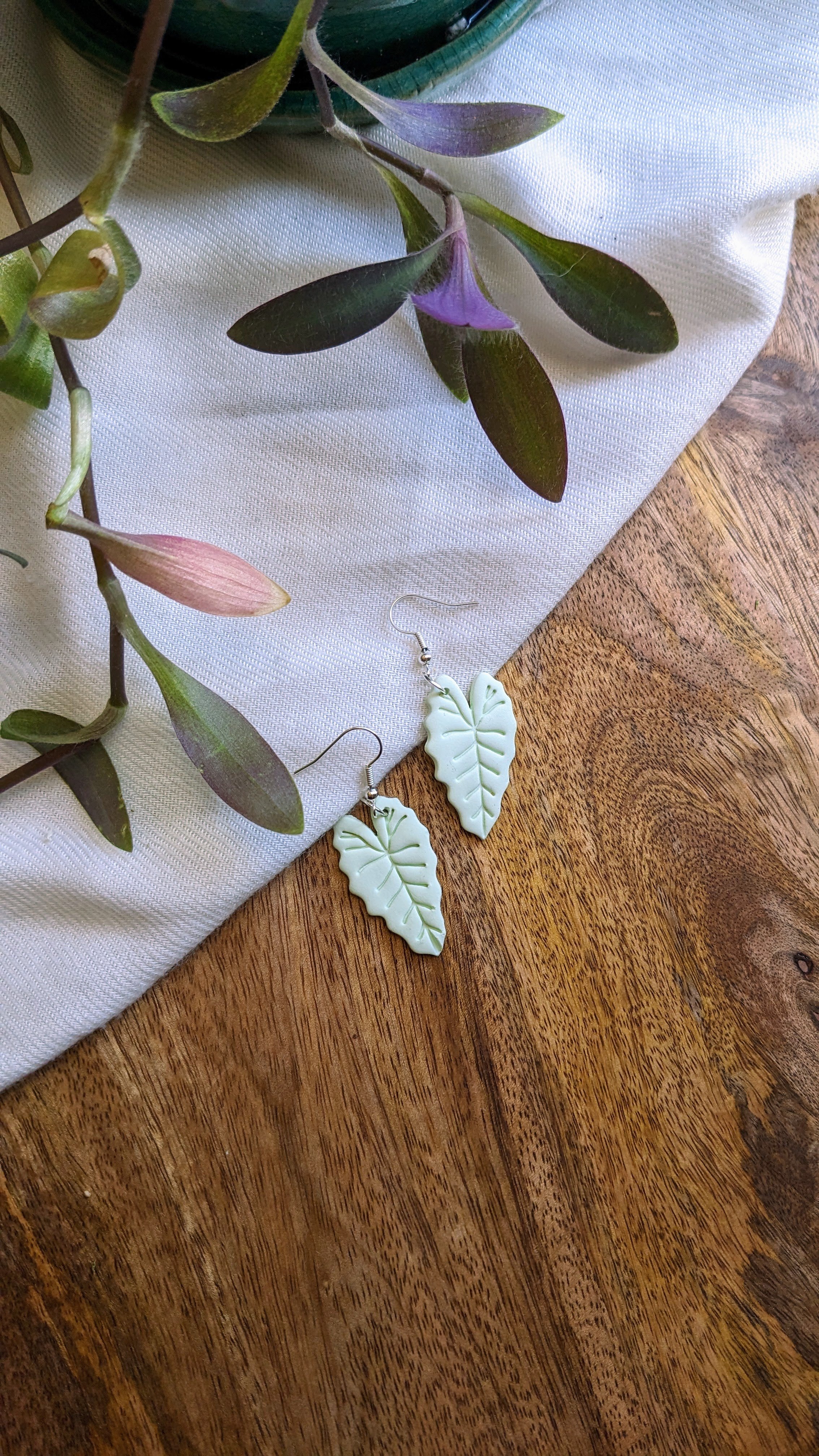 Handcrafted polymer clay earrings. Light green leaf shape with silver fish hook top. All components are gold plated, silver plated, or stainless steel with sensitive ears in mind.