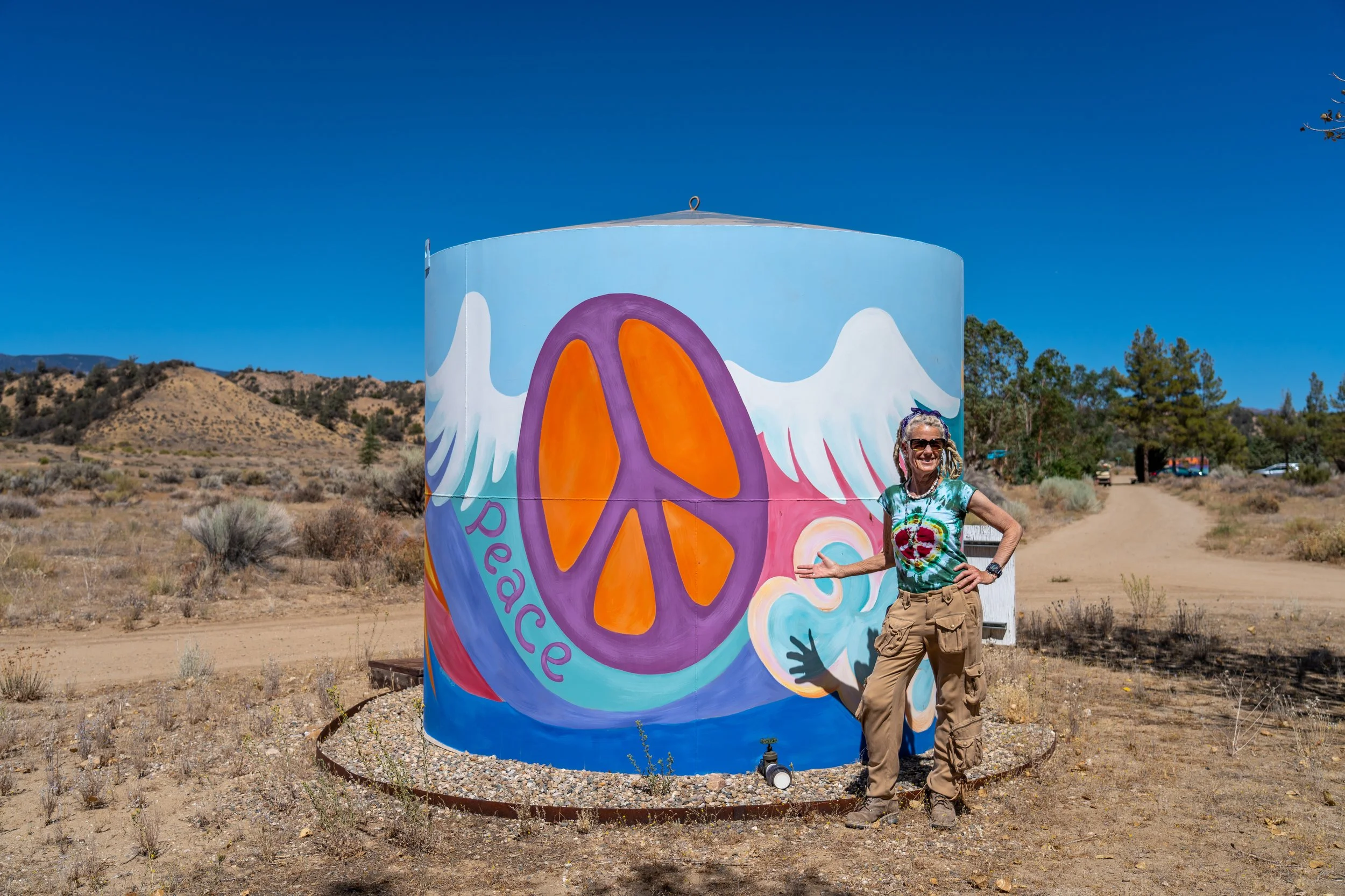 Pop Artist MB painted a water tank and transformed it into beautiful art with symbols of Love, Peace & Happiness 