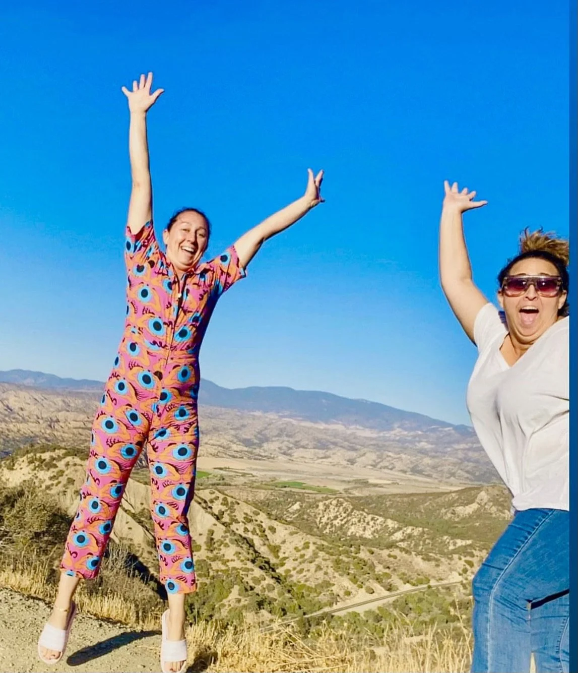 Joey and Katie jumping for joy on their hike