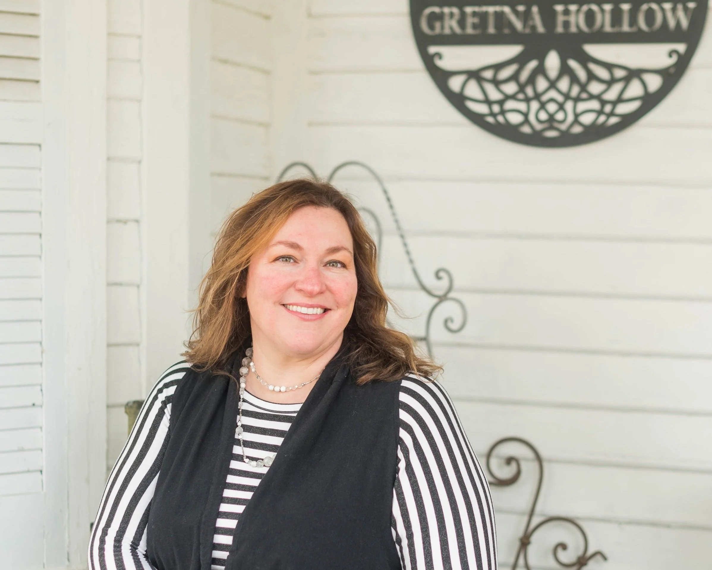 Michelle Mercurio sitting on her porch outside of Gretna Hollow retreat house