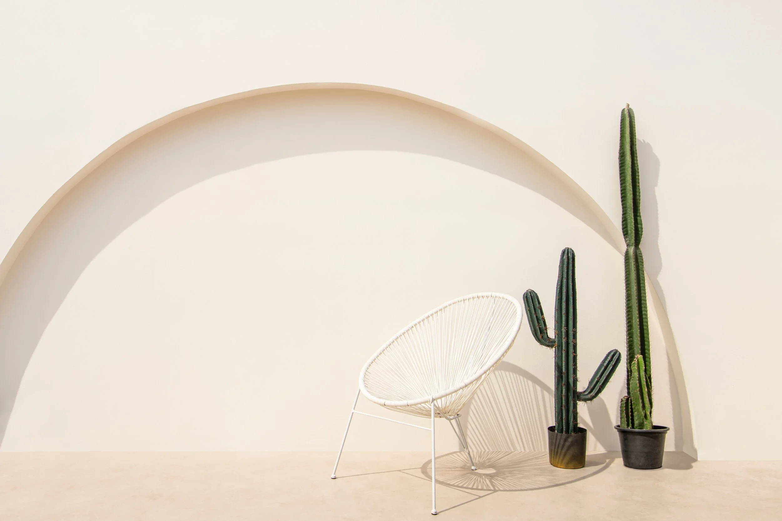 Image of a white chair in front of a beige wall with cacti. Discover how ketamine assisted therapy in Pasadena, CA can help you effectively manage and cope with your anxiety symptoms.