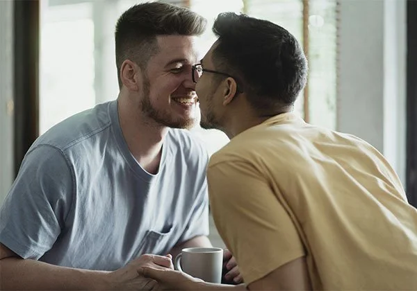 Men couple in a cute, intimate moment represents how working with an attachment-based therapist in Los Angeles & Pasadena can help you in your adult relationships.