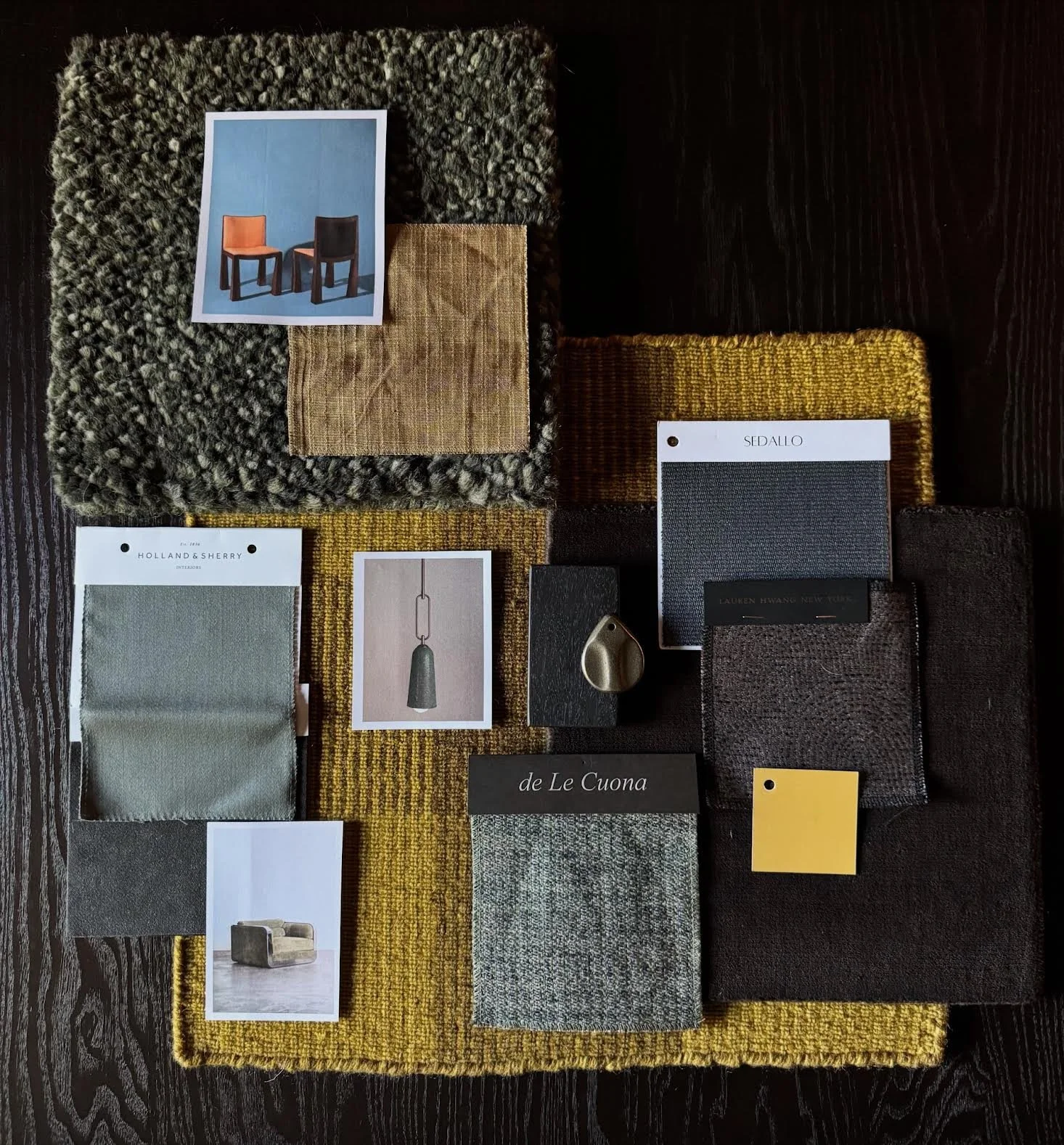 A collection of fabric swatches, color samples, and mood board images laid out on a wooden surface for interior design.