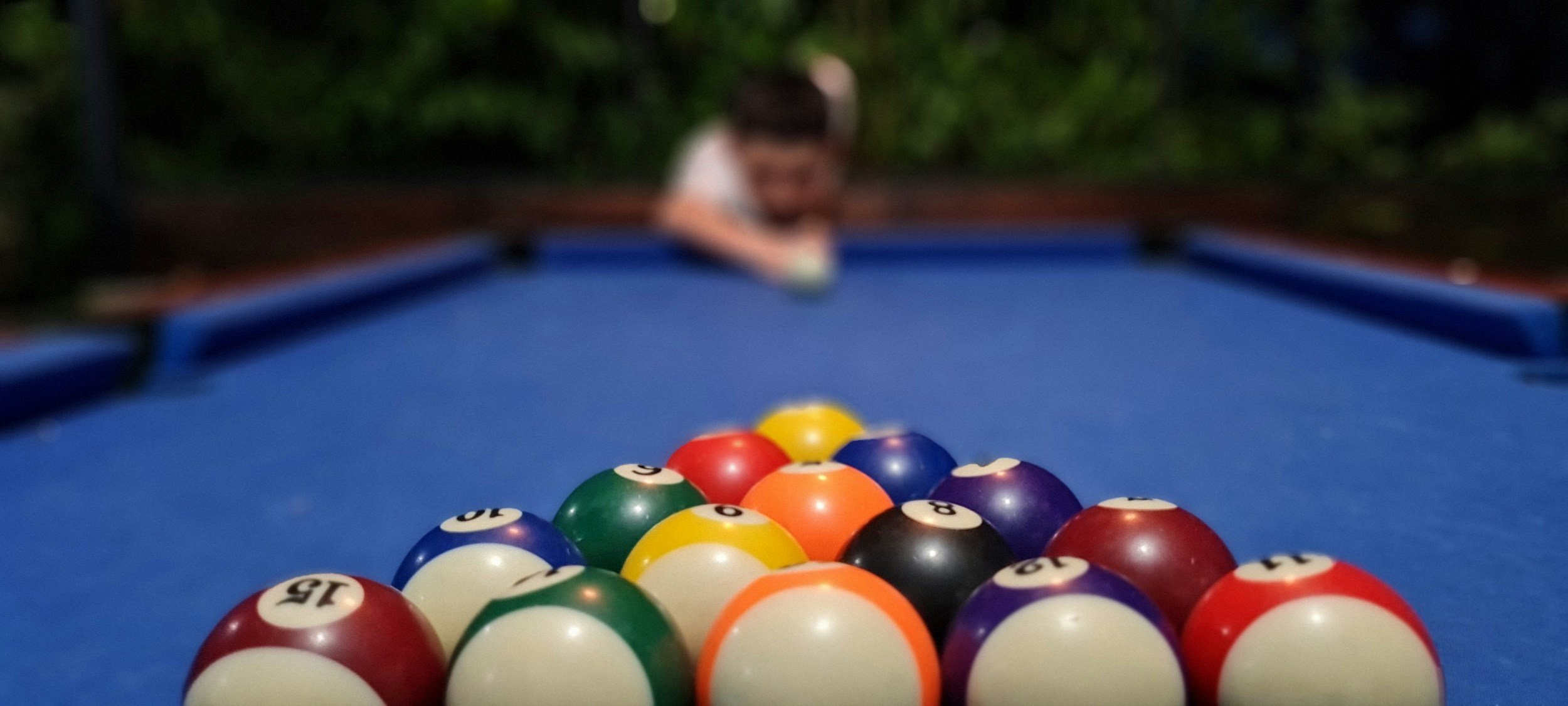 player getting ready to break pool table balls that are set up
