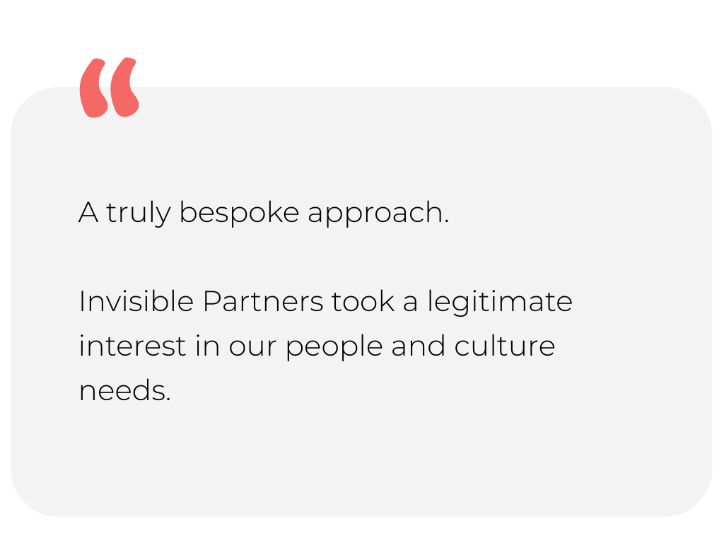 Snow-capped mountains in the background with a grassy hill in the foreground under a cloudy sky.