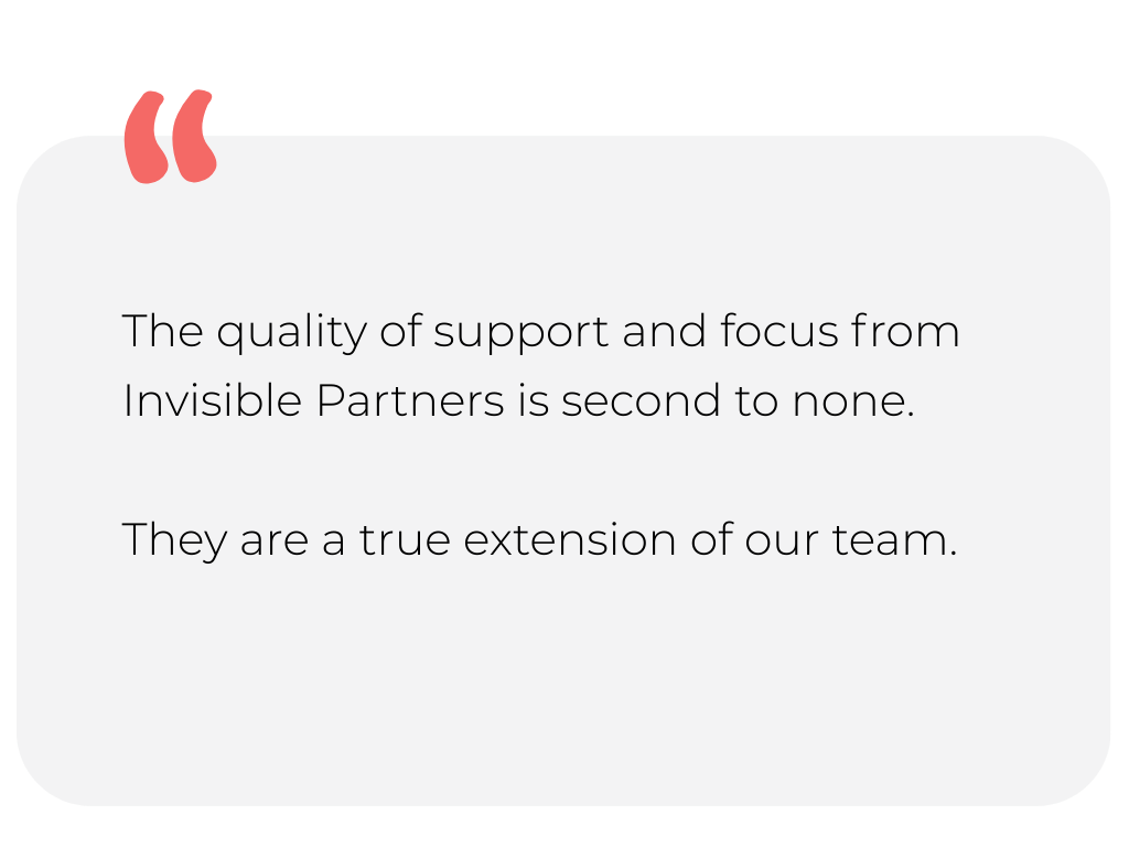 Mountain range with some snow on the peaks and grass-covered hills in the foreground under a clear sky