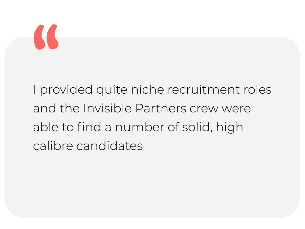 Scenic view of a turquoise lake with green hills in the foreground and mountain ranges with grey peaks in the background under a cloudy sky.