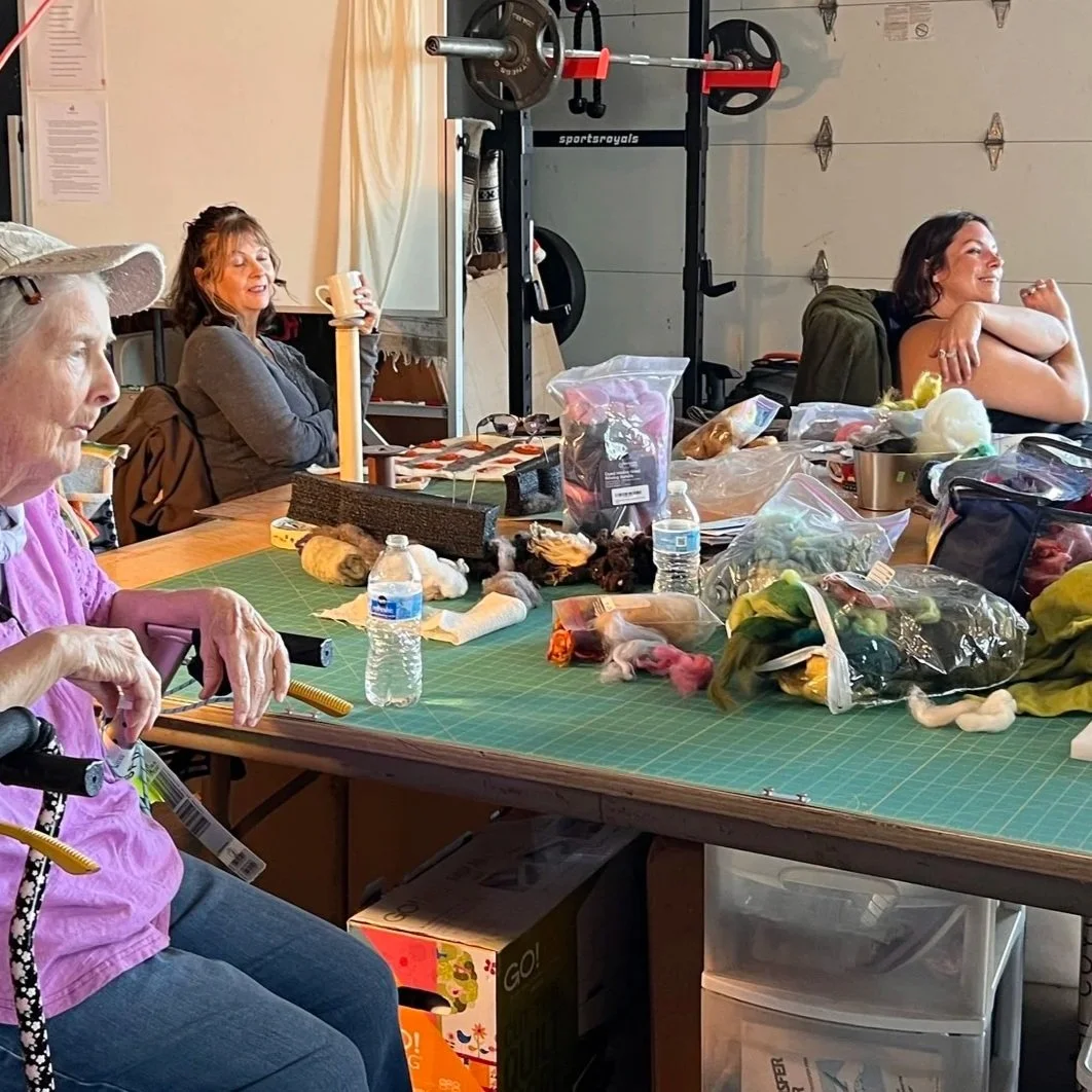 A small group of people learning wool craft