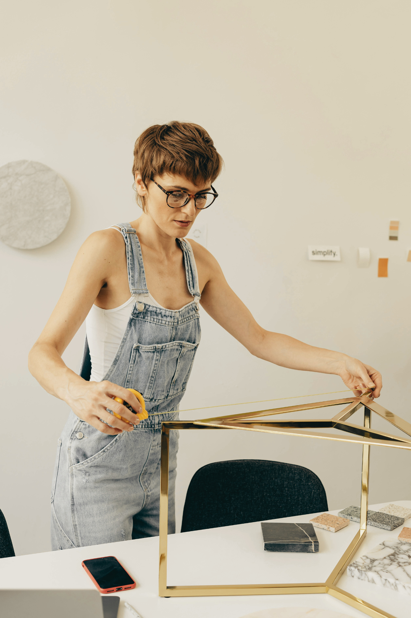 A woman measuring a metal structure