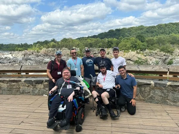group of young adults some in wheelchairs beautiful scenery