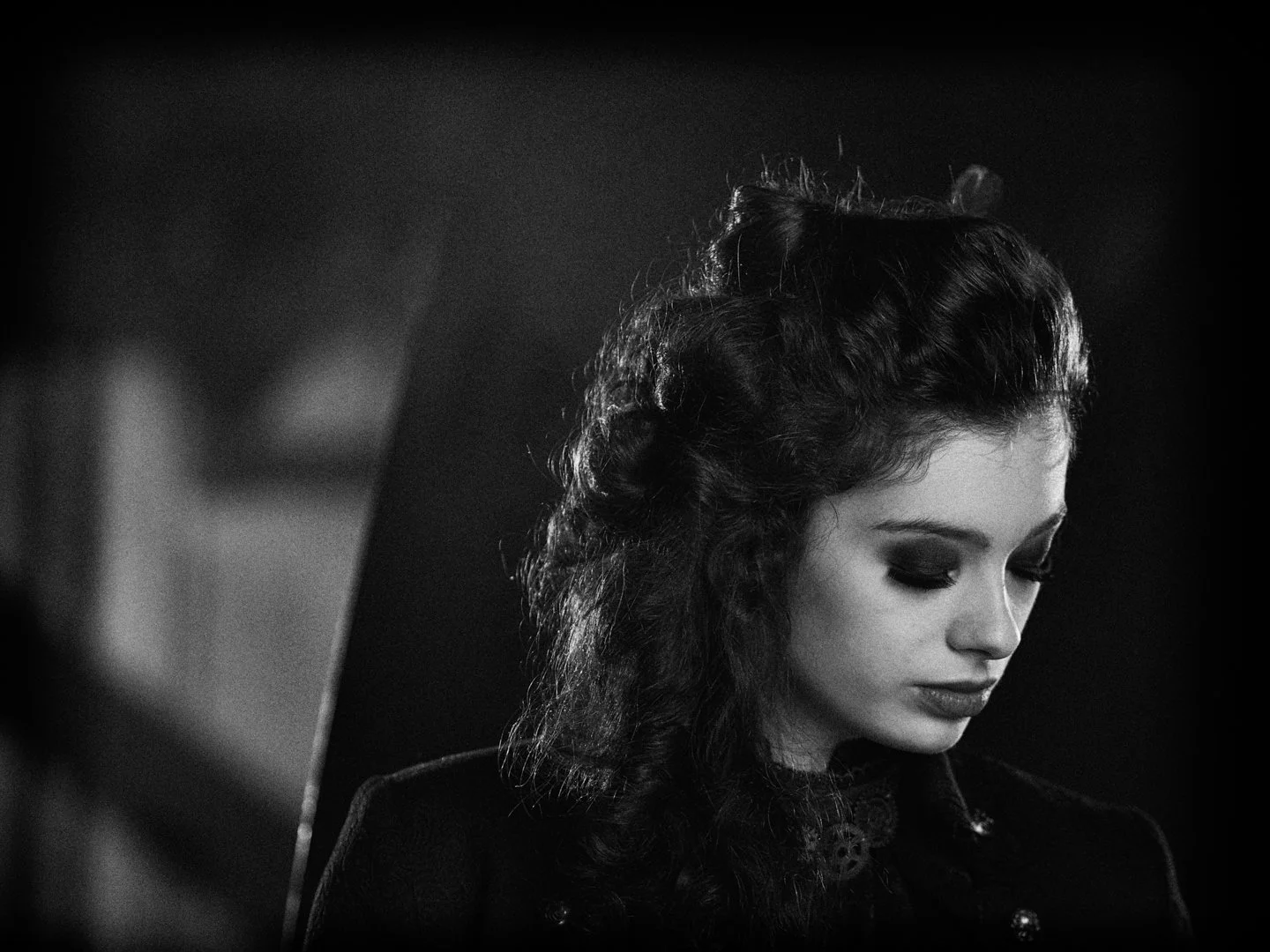 Sort-hvid foto af en kvinde med mørkt, krøllet hår, med øjne lukkede og et afbalanceret udtryk.