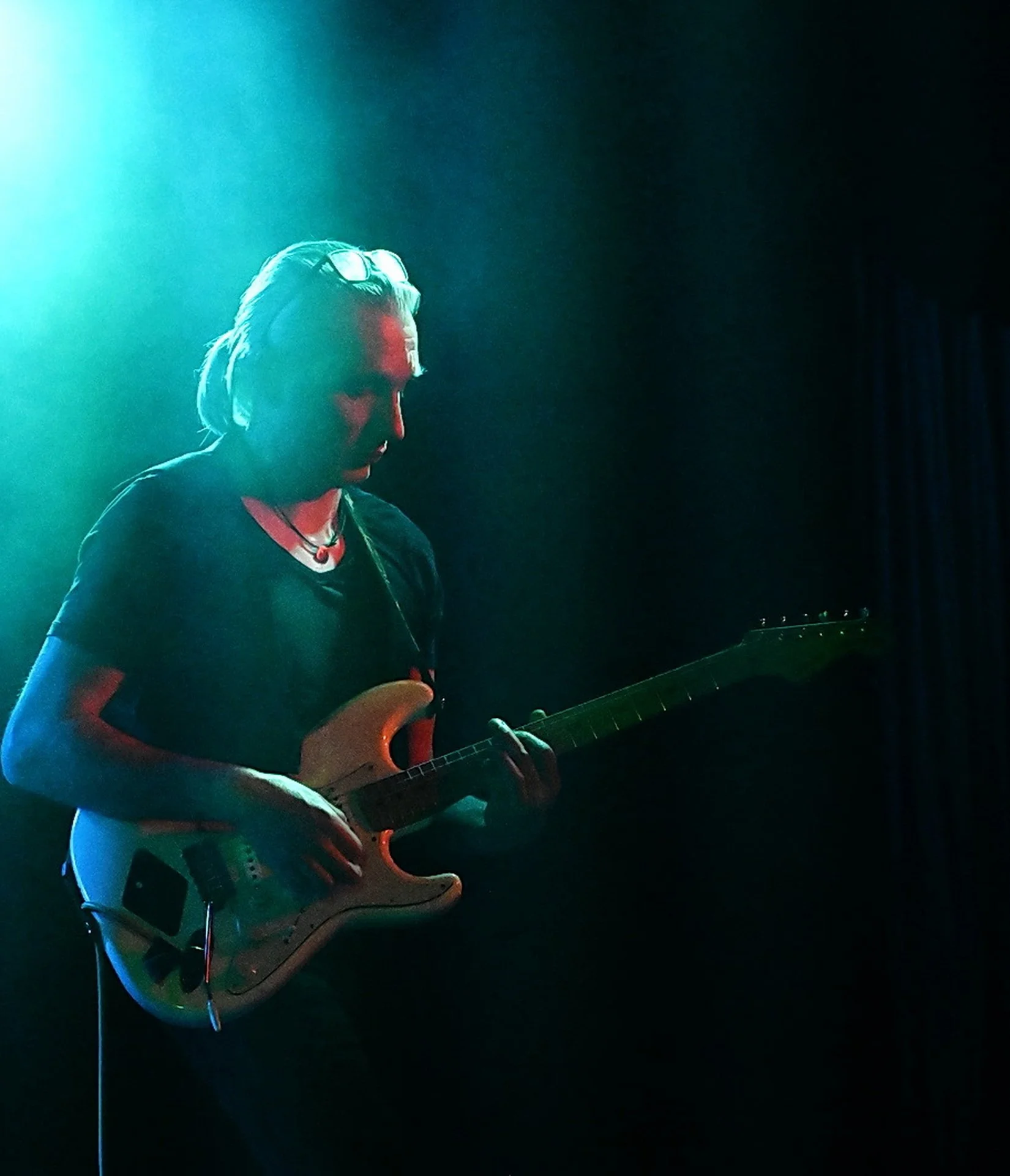 Elektrisk guitarmagi under koncert

Guitarist i blågrønt lys med elguitar under stemningsfuld livekoncert

