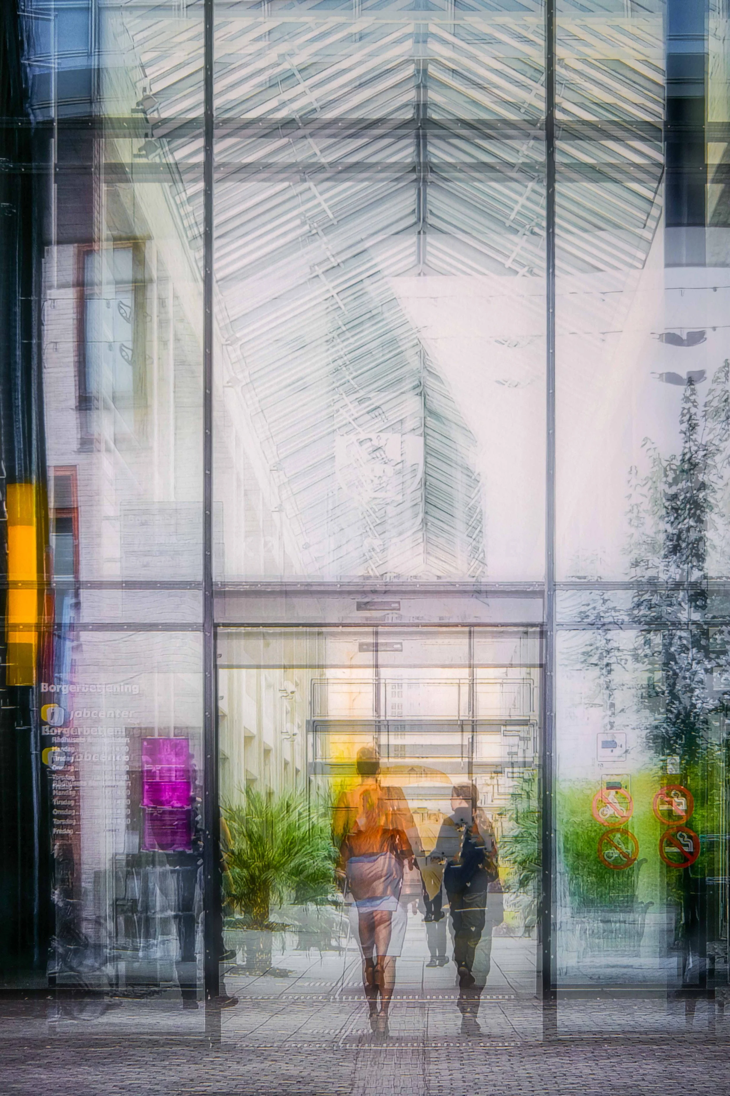 Lysfyldt moderne bygning med glasfacade og mennesker i silhuet. Gennemsigtighed og arkitektur i harmoni – moderne glashal med mennesker i bevægelse.