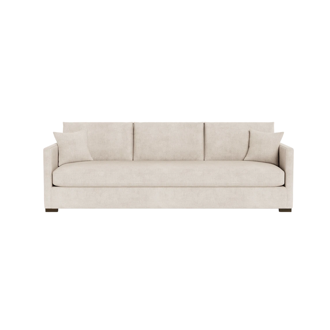 A beige fabric sofa with three cushions against a white background.