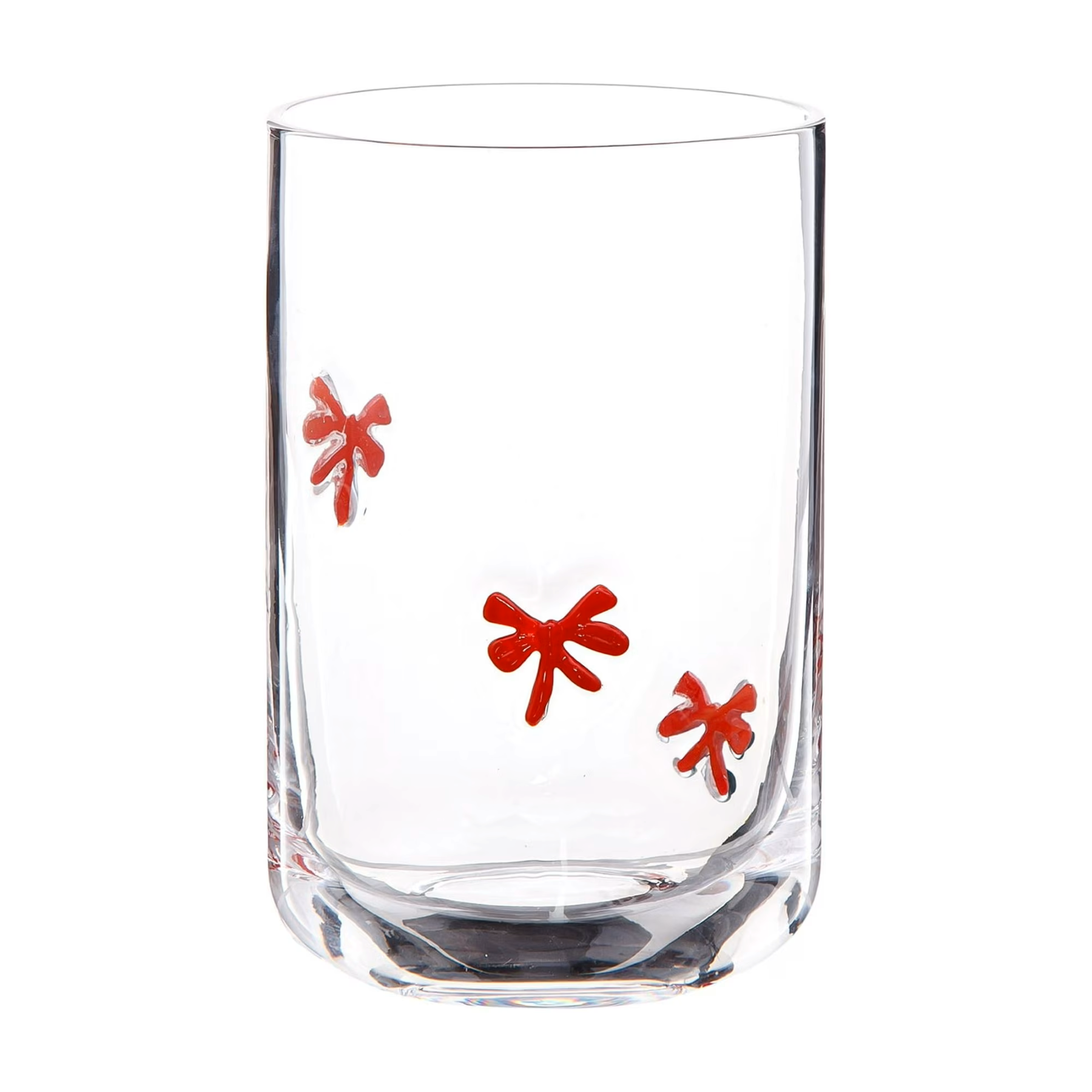Clear glass tumbler with red flower-shaped designs inside.