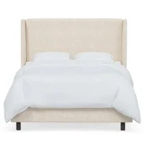 A neatly made bed with white bedding and pillows in a neutral-colored room.