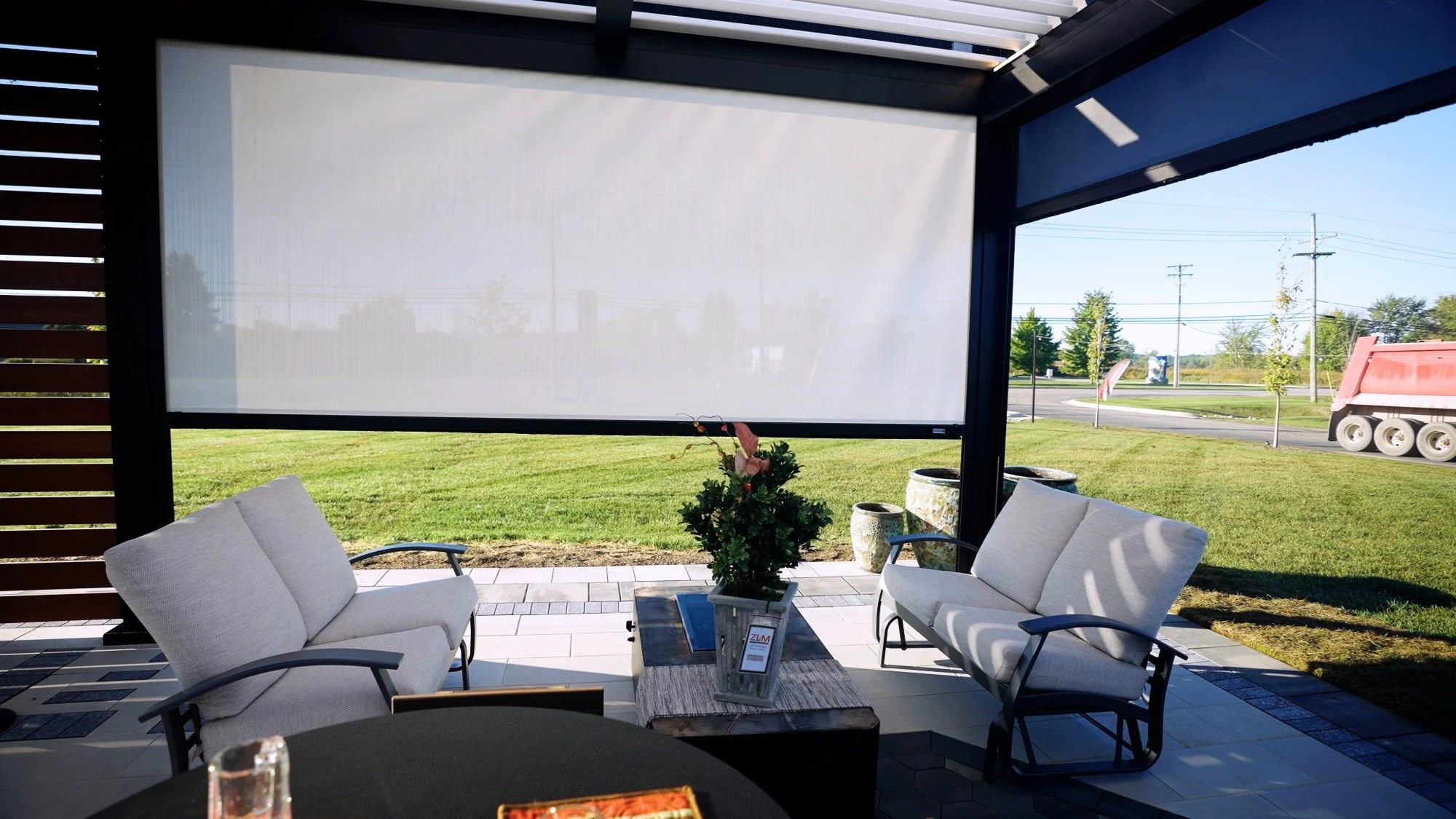 Poolside pavilion lounge seating with retractable privacy screen and outdoor decor