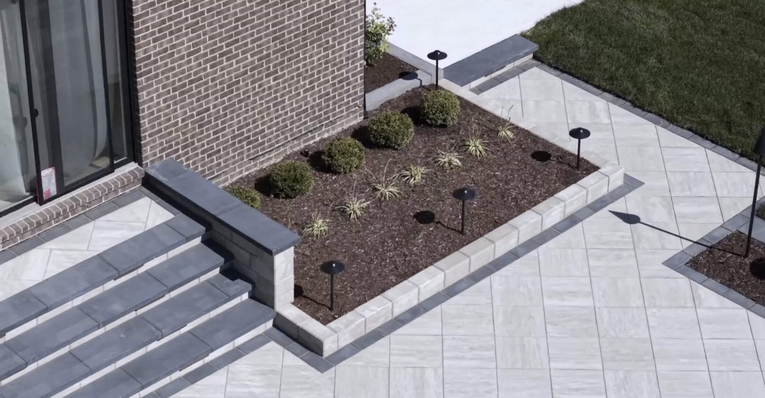 Sophisticated outdoor living environment structured around custom pool design in Troy, Shelby Township, and Rochester Hills, MI with coordinated landscape lighting