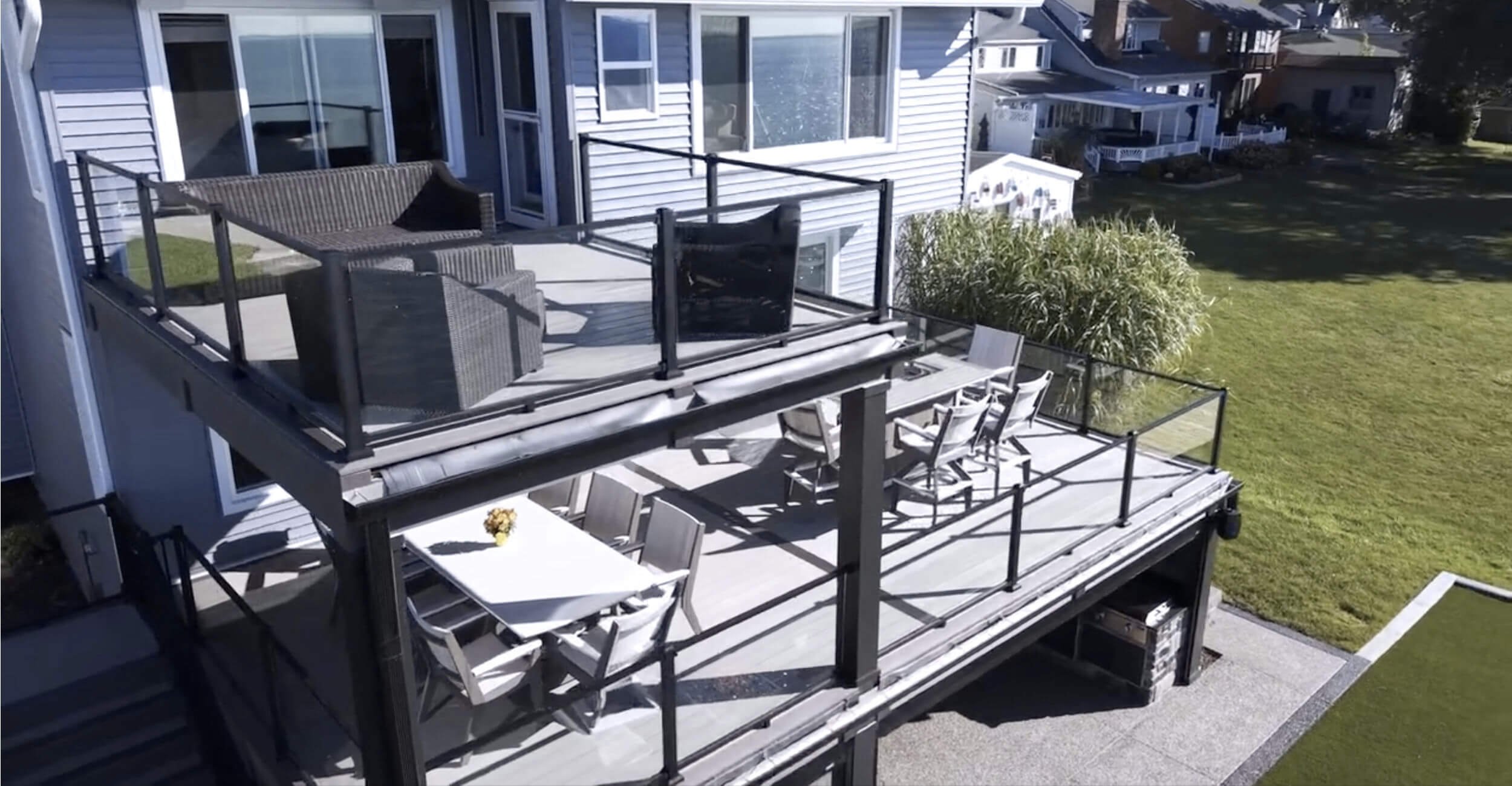 Elevated deck transition flowing into cohesive backyard oasis design in Troy, Shelby Township, and Rochester Hills, MI