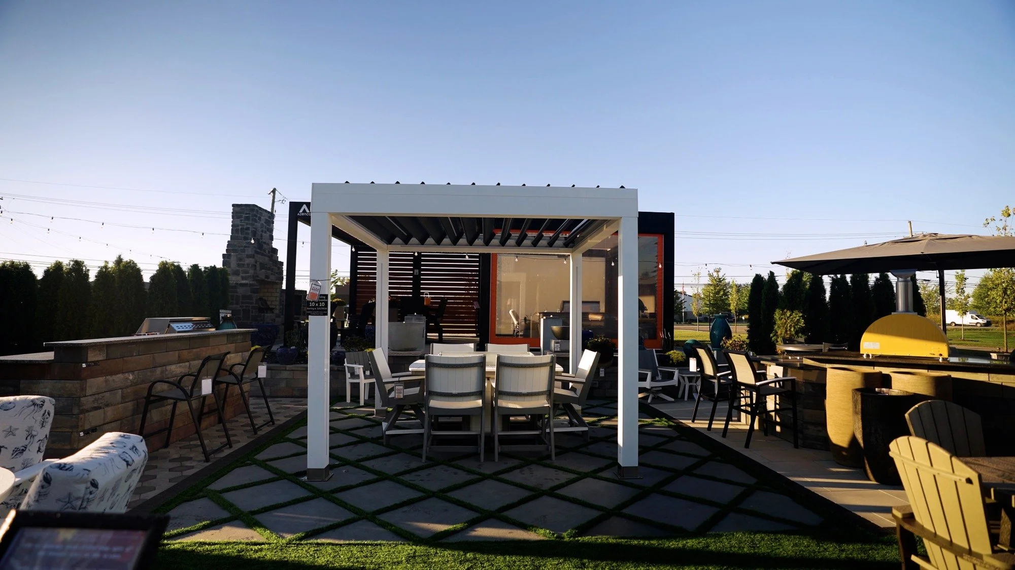 Backyard pavilion display with dining table, pergola structure, and paved patio