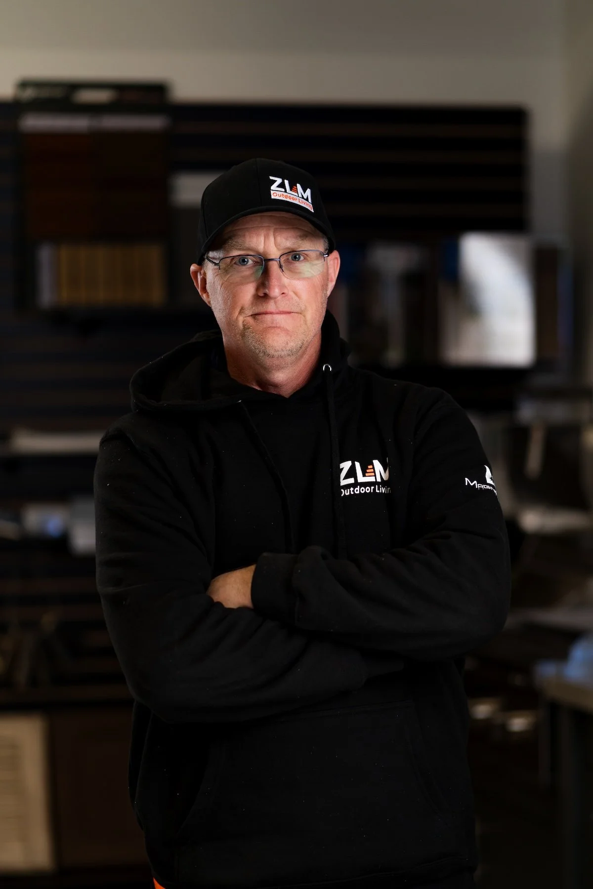 Man wearing glasses and wearing black hoodie with ZLM logo