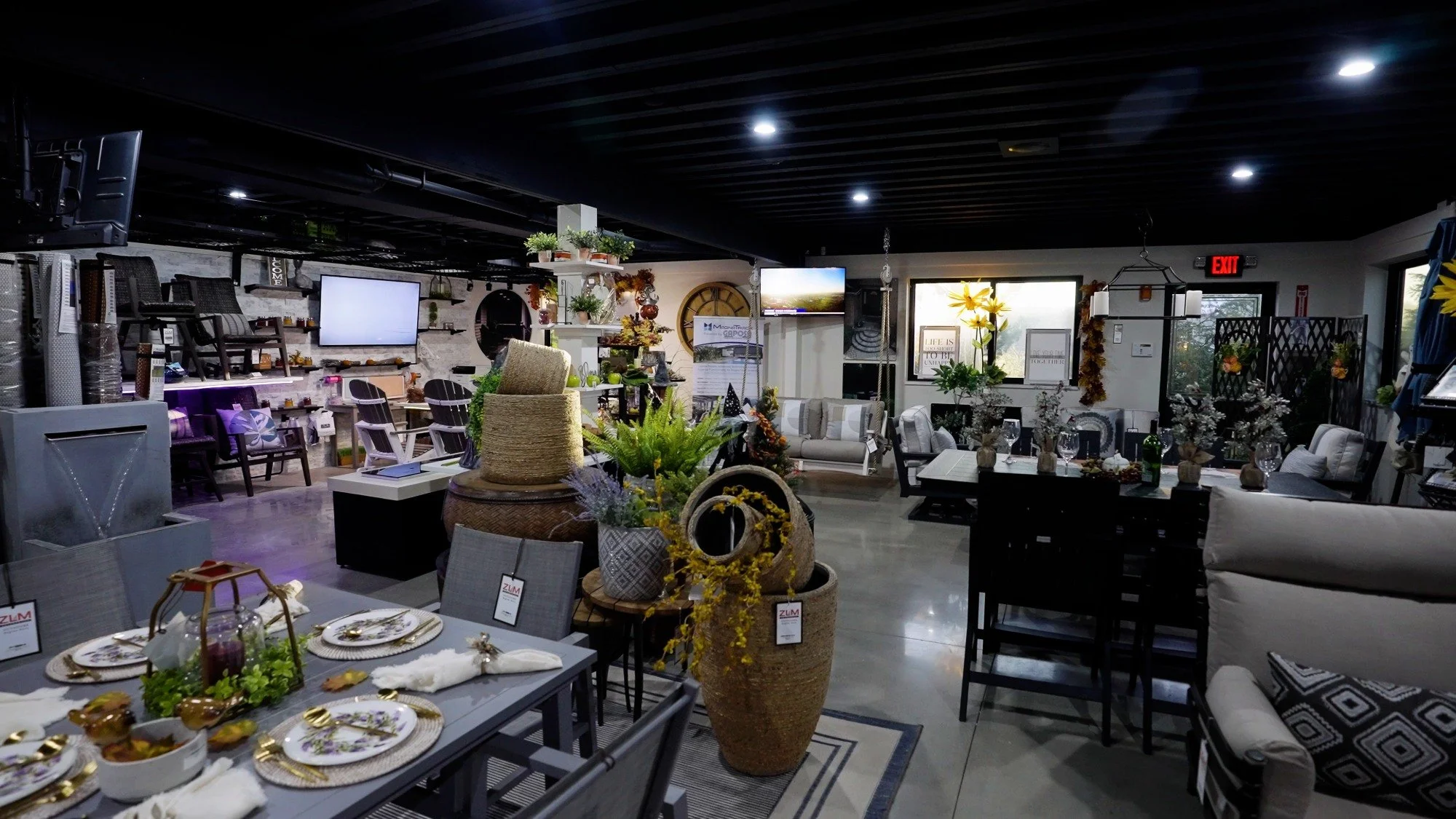 Indoor showroom display with outdoor furniture, tables, and decorative accessories