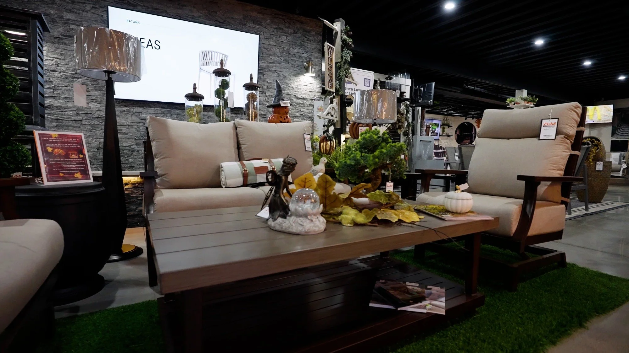 Showroom dining table display with seating, decor, and branded pillow accents