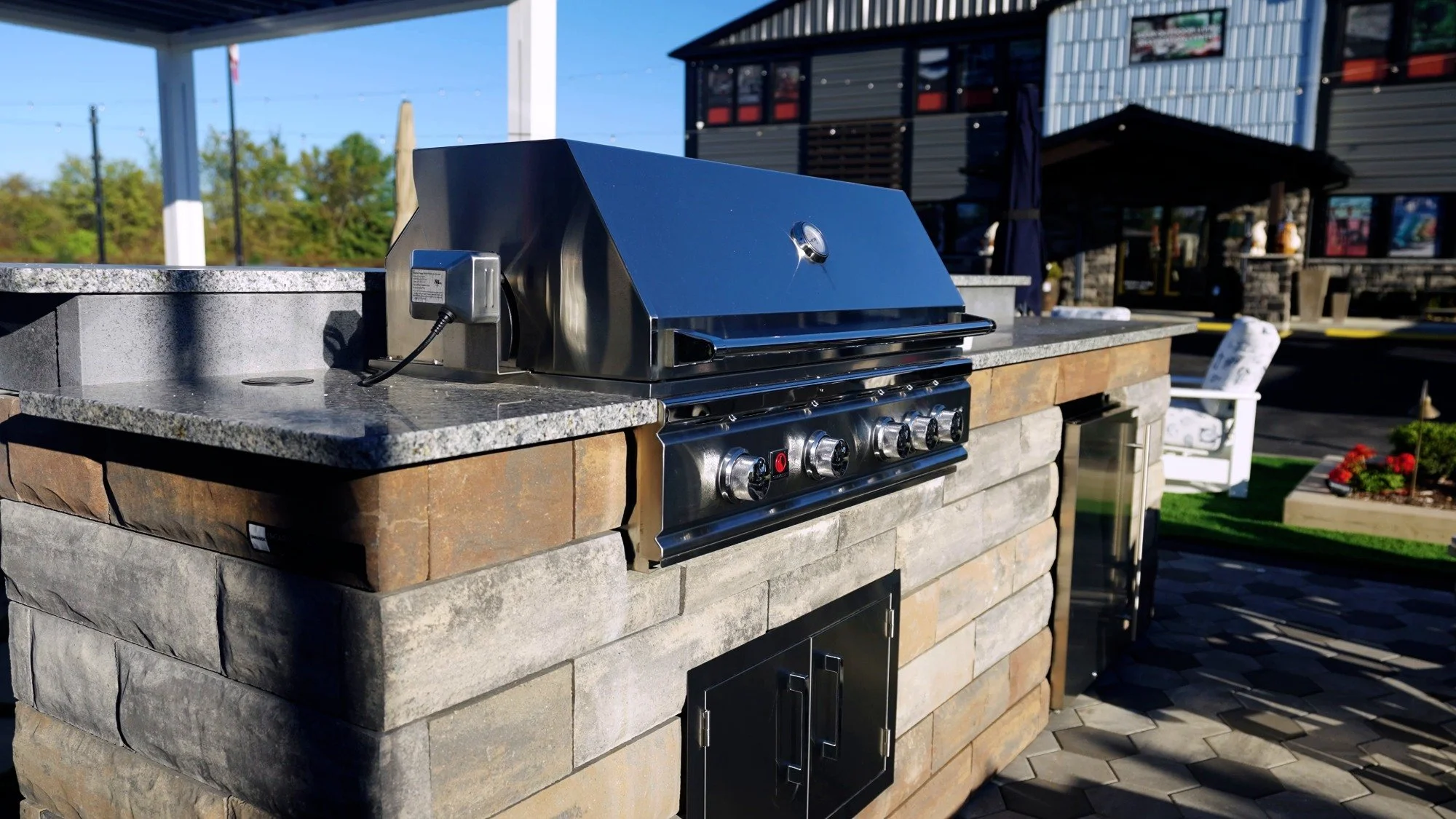 Outdoor kitchen with stone veneer and built-in grill on display at the ZLM Outdoor Living showroom in Casco, MI