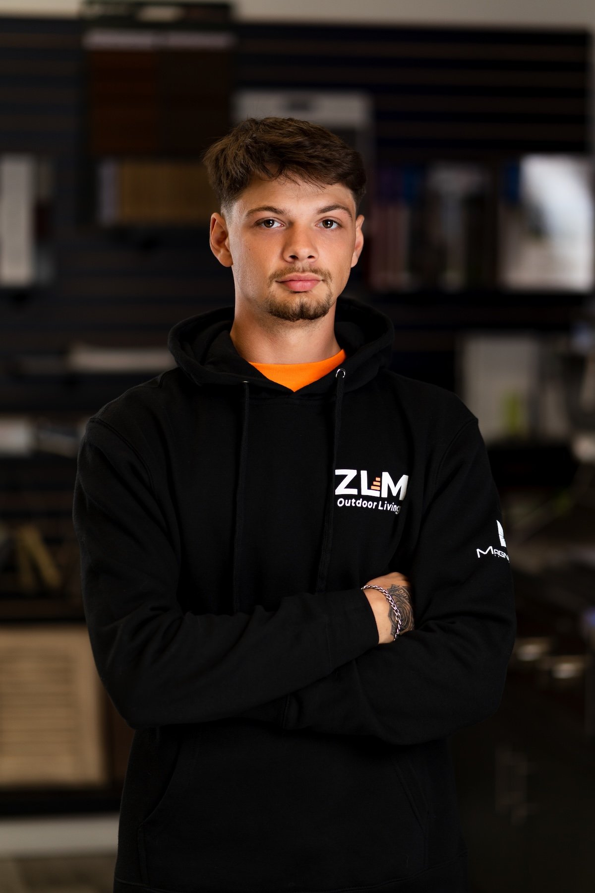 Young man wearing a black hoodie with ZLM logo