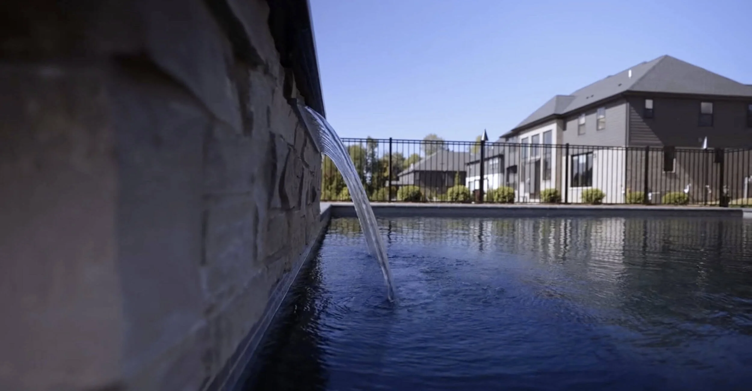 Elevated spa spillover enhancing the sophistication of custom pool design in Troy, Shelby Township, and Rochester Hills, MI