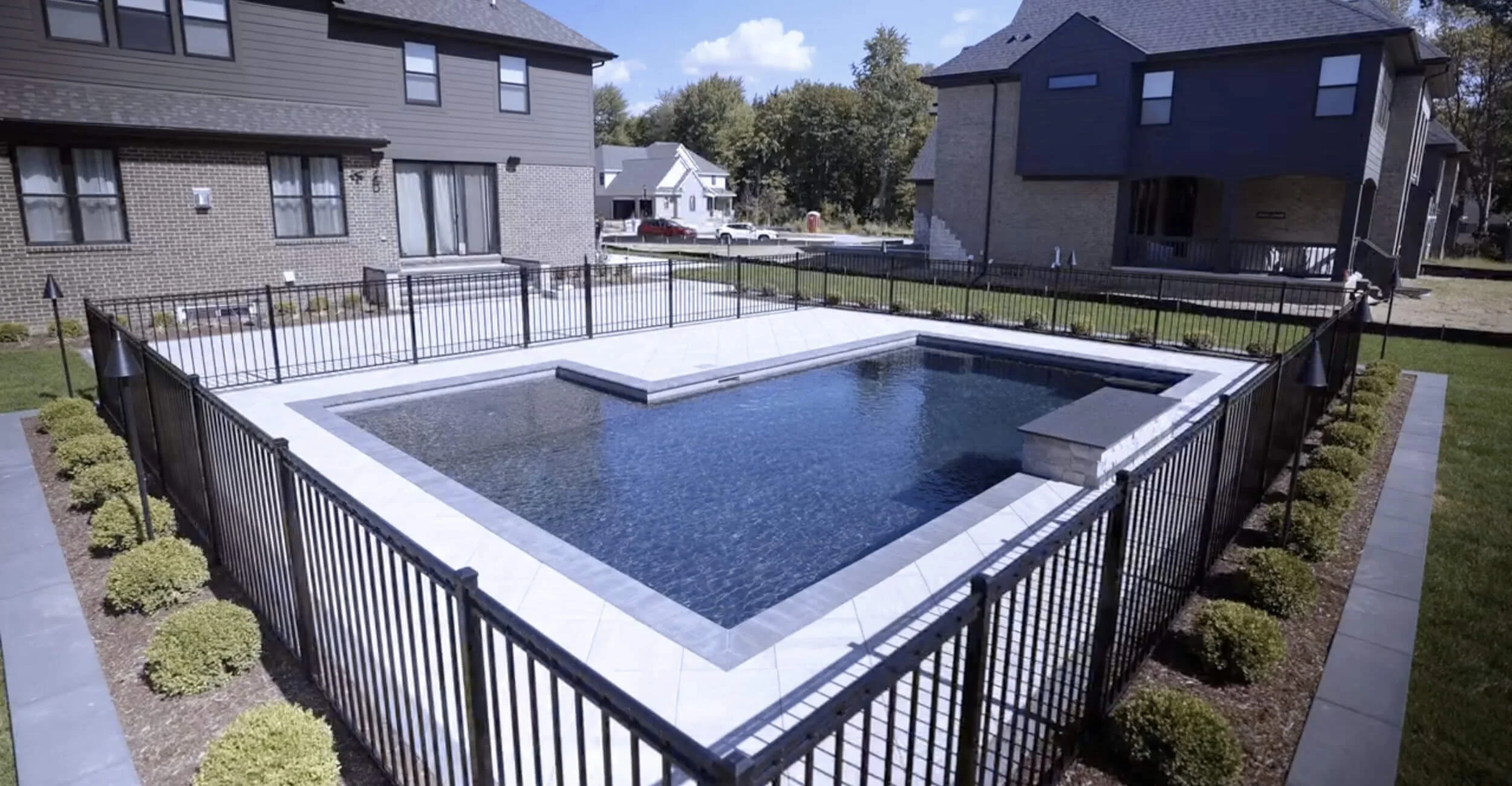 Minimalist poolscape demonstrating high-end custom pool design in Troy, Shelby Township, and Rochester Hills, MI with smooth concrete decking