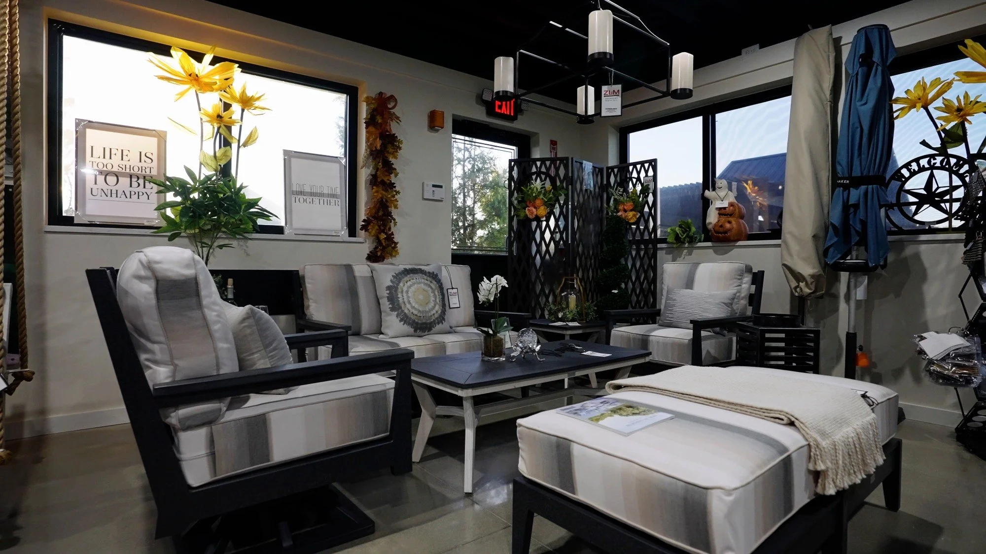 Luxury patio furniture display with lounge seating and decorative wall accents