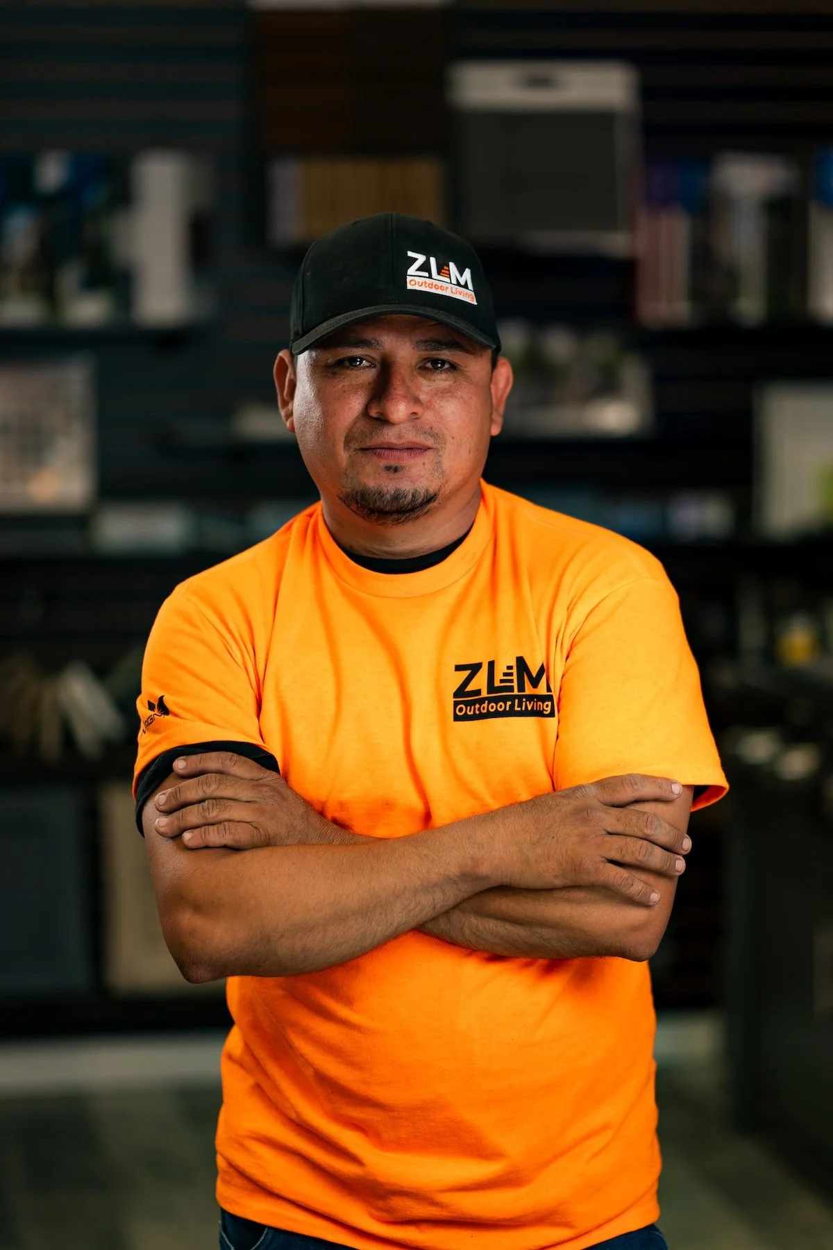 ZLM employee wearing orange t-shirt and black hat with ZLM logo