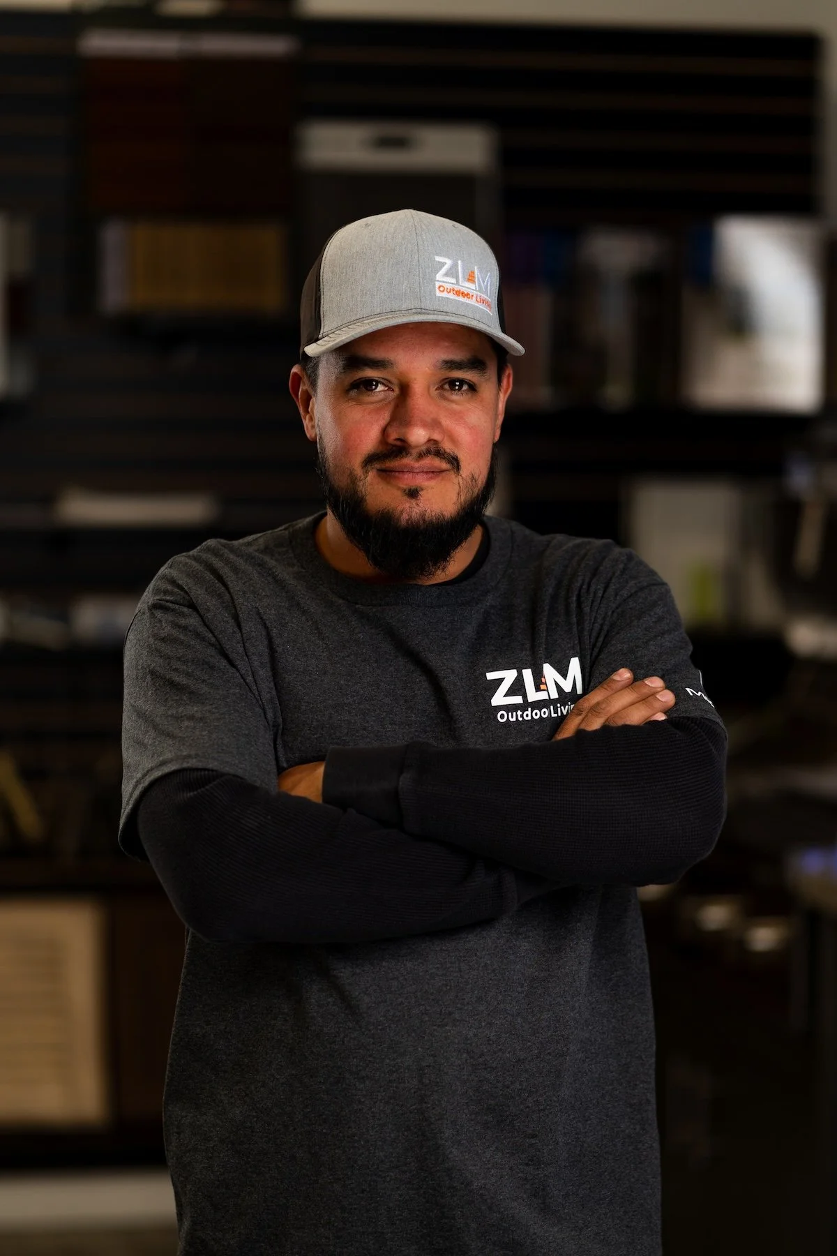 Man with light gray hat and dark gray t-shirt with the ZLM Outdoor Living logo