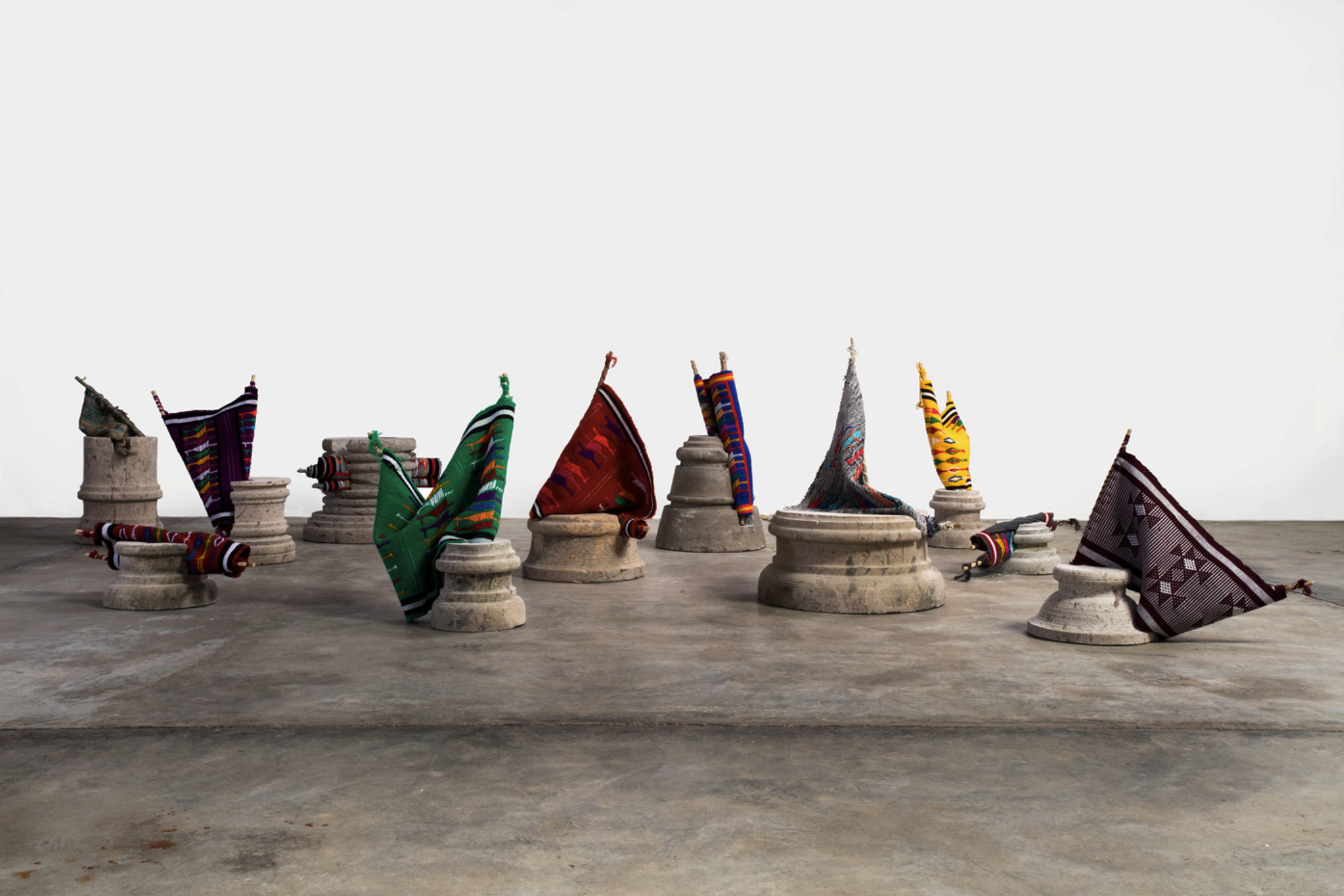 Cántico del descenso, 2014. Conjunto de 10 piezas conformadas por rocas de cantera, textiles realizados en telar de cintura, enjulios de madera. Dimensiones variables. Fotografía de Francisco Kohen. Obra presentada en el Arsenale, en la 57ª Exposició