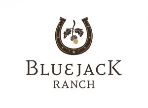 Logo for Bluejack Ranch featuring a horseshoe with grapevines and a pine cone, with the name 'Bluejack Ranch' below.