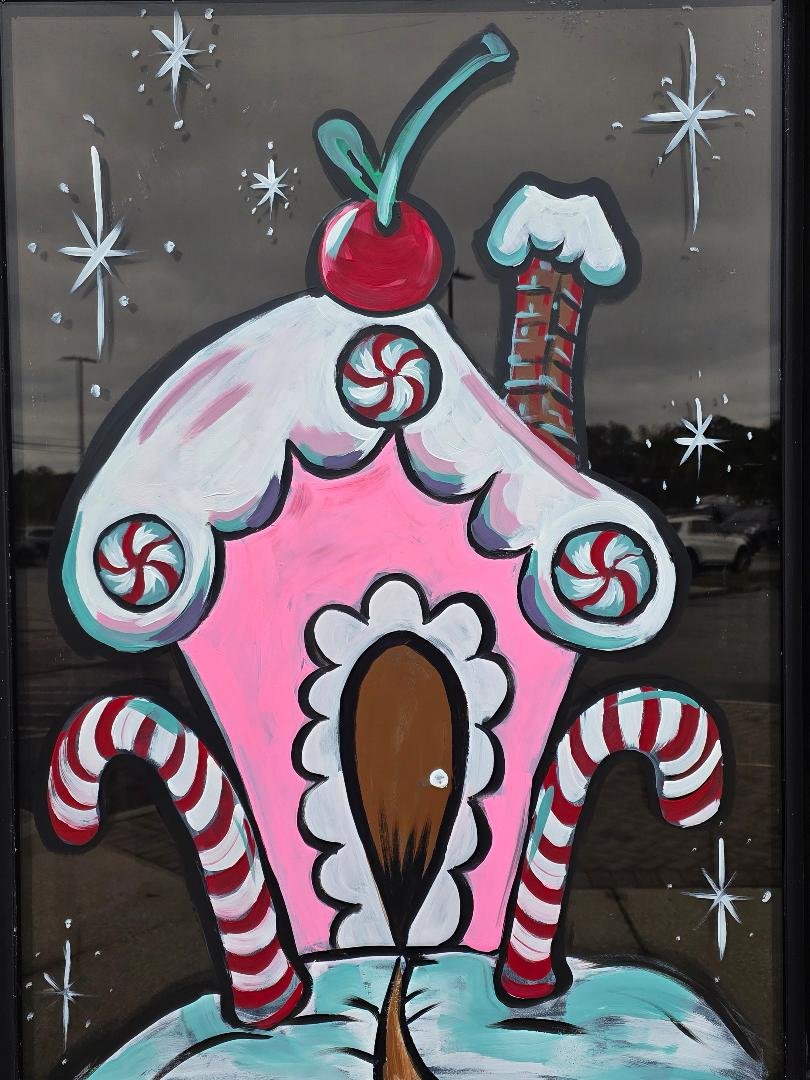 Colorful illustration of a gingerbread house decorated with peppermint candies, a cherry on top, and surrounded by snowflakes and stars. window painting