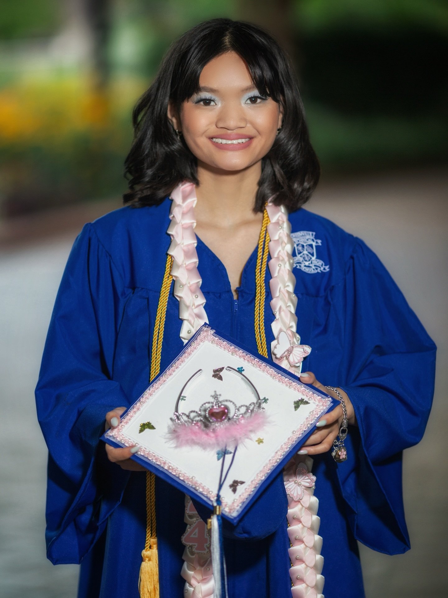 She showed up as exactly who she is &mdash; crown and all. 👑
The decorated cap, the leis, the cords she earned &mdash; every detail tells the story of a girl who worked hard and made it count. THIS is what senior portraits look like when you bring Y