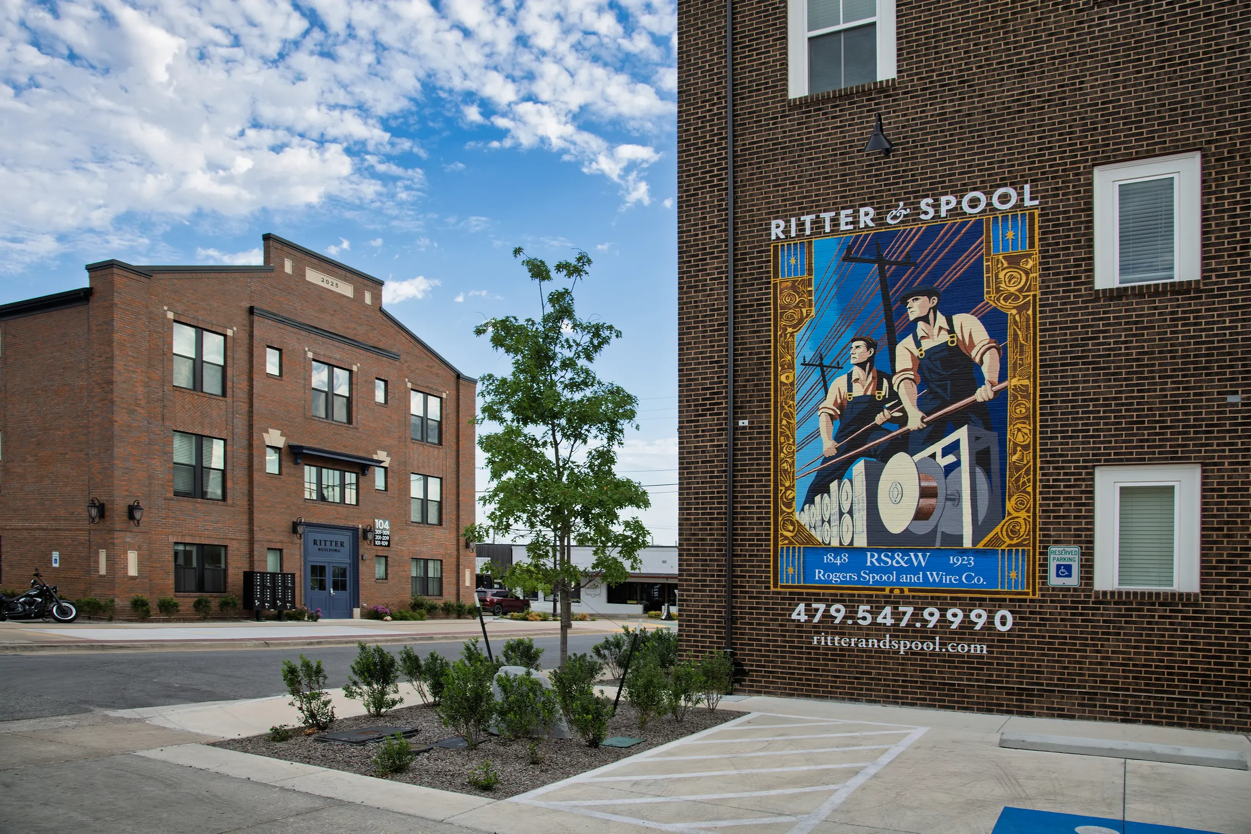 Brick buildings with a large Ritter & Spool mural advertising Rogers Spool and Wire Co.